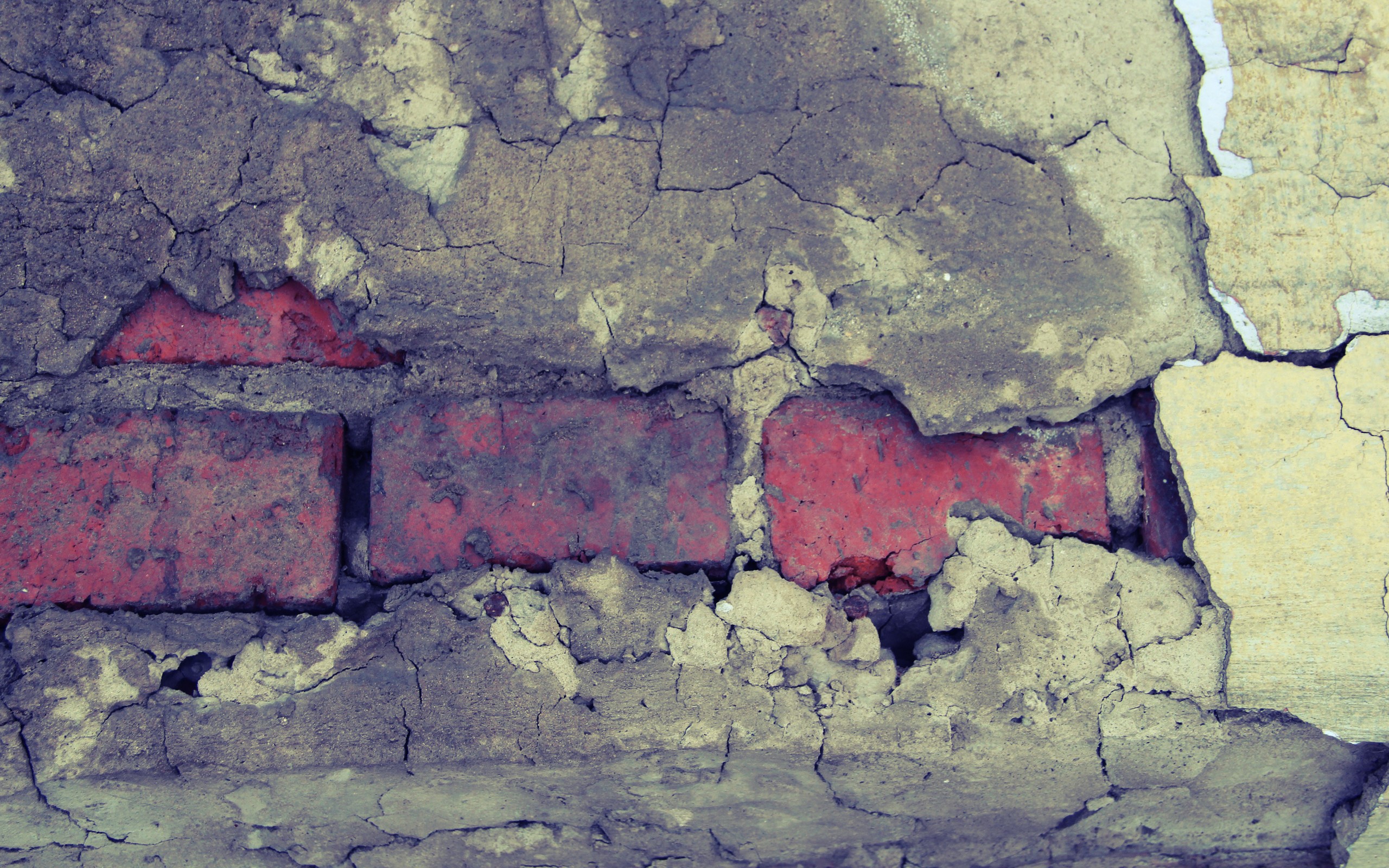Cracked plaster wall revealing red bricks HD Wallpaper