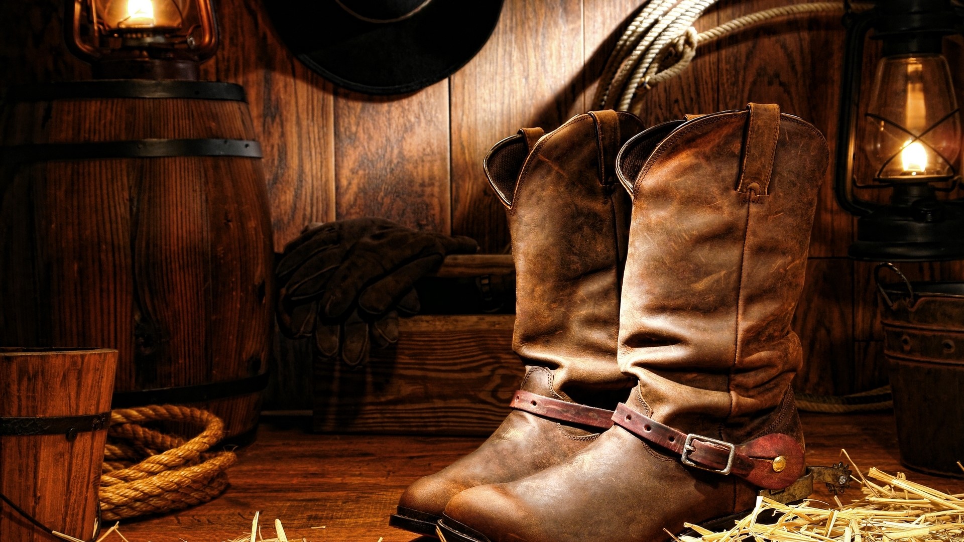 Cowboy boots, barrel, and lanterns on wooden background HD Wallpaper
