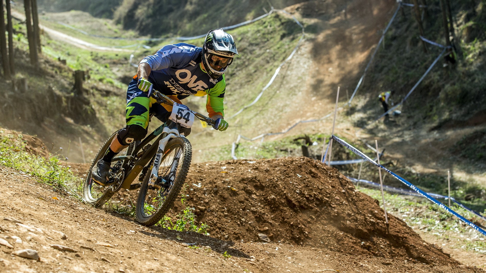 Mountain biker with number 54 on a dirt track HD Wallpaper
