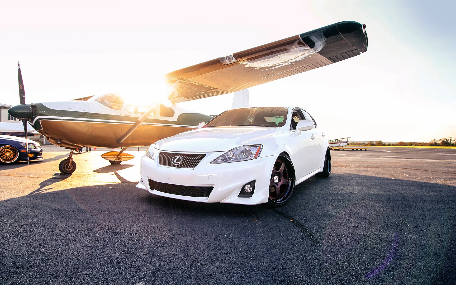 White Lexus IS parked next to a small airplane HD Wallpaper
