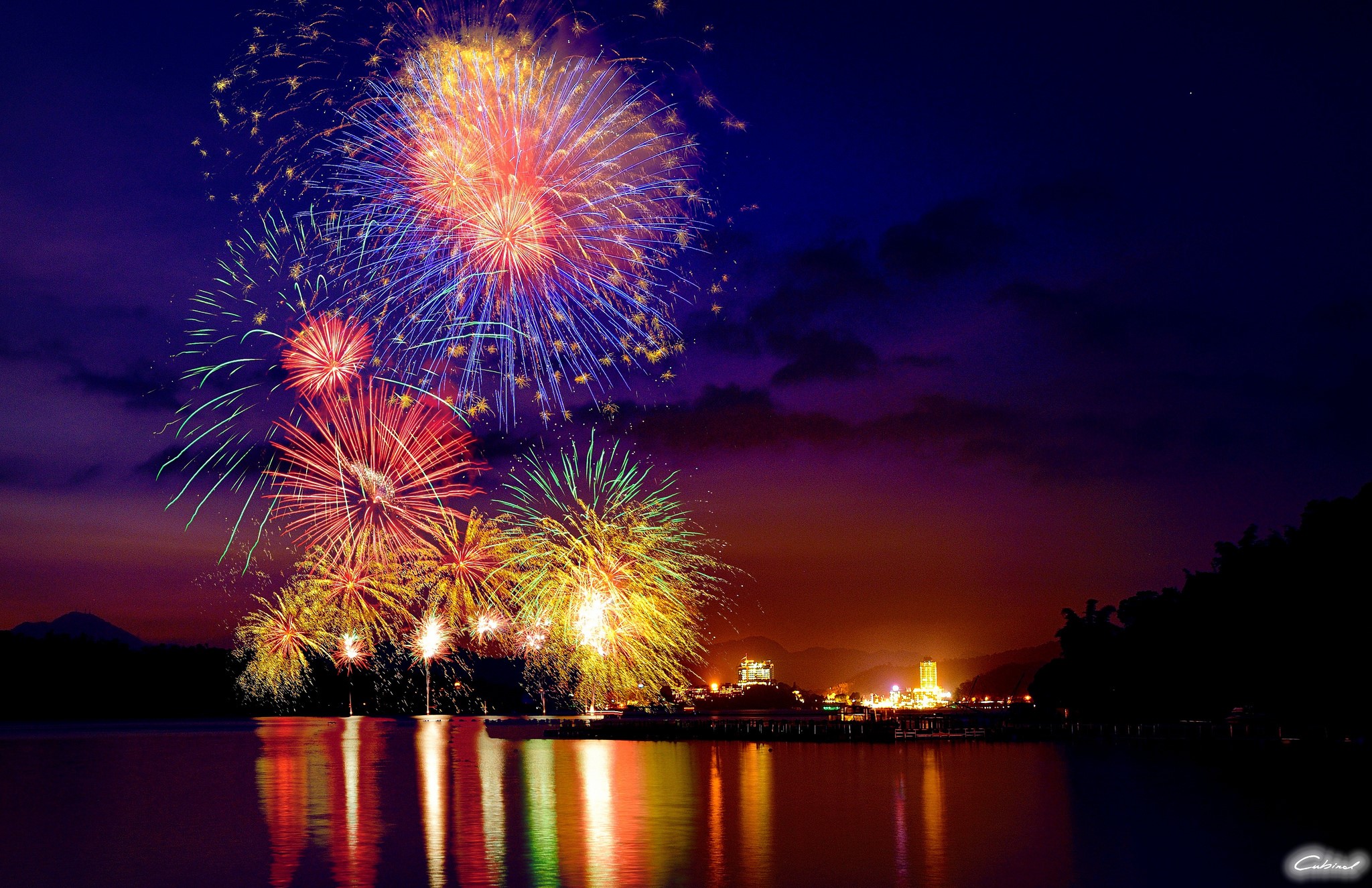Fireworks over a city skyline at night HD Wallpaper