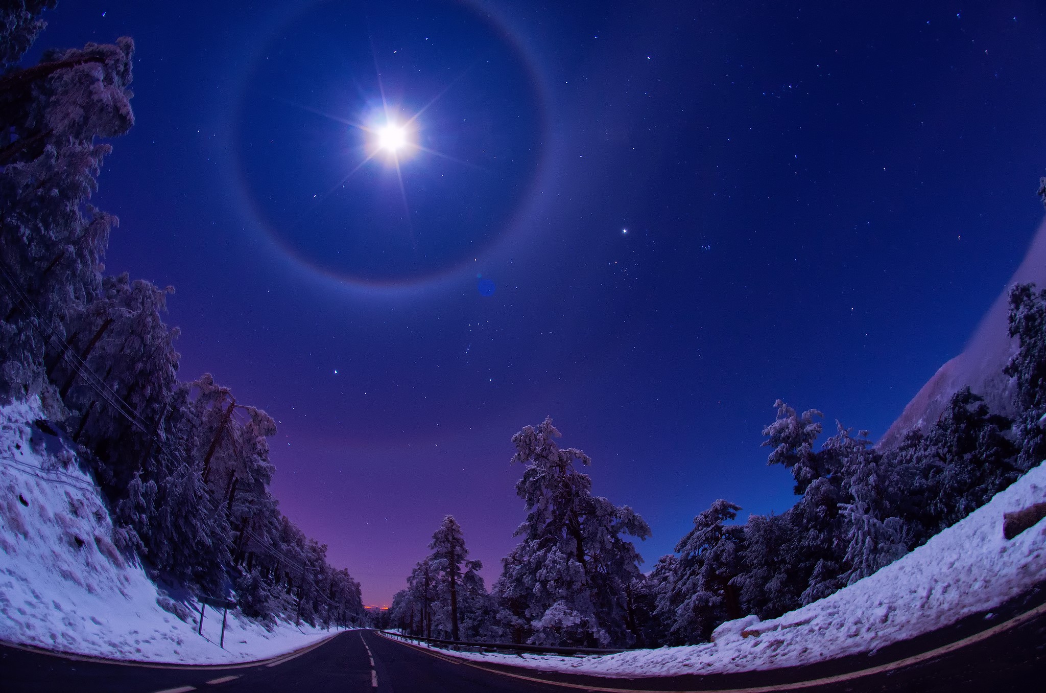 Moon halo over snowy road at night HD Wallpaper