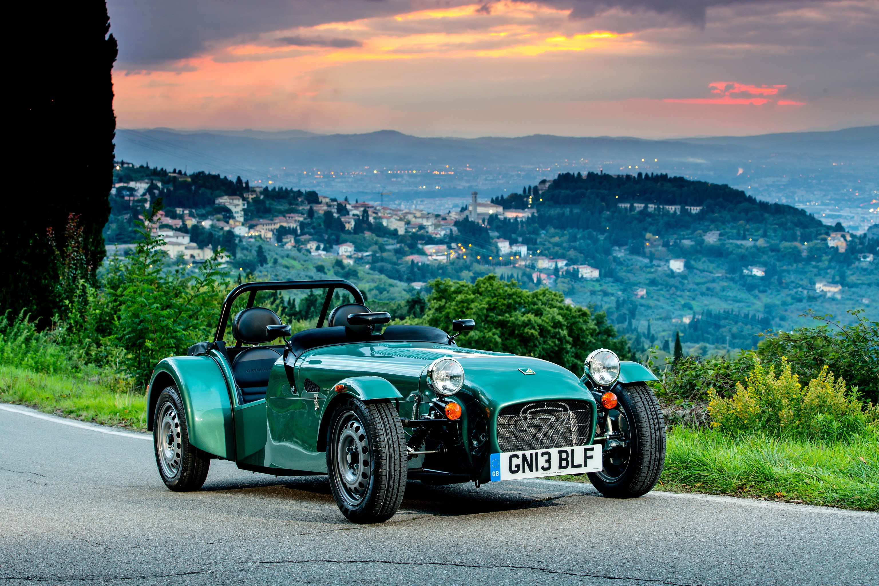 Green Caterham 7 car on a scenic road HD Wallpaper