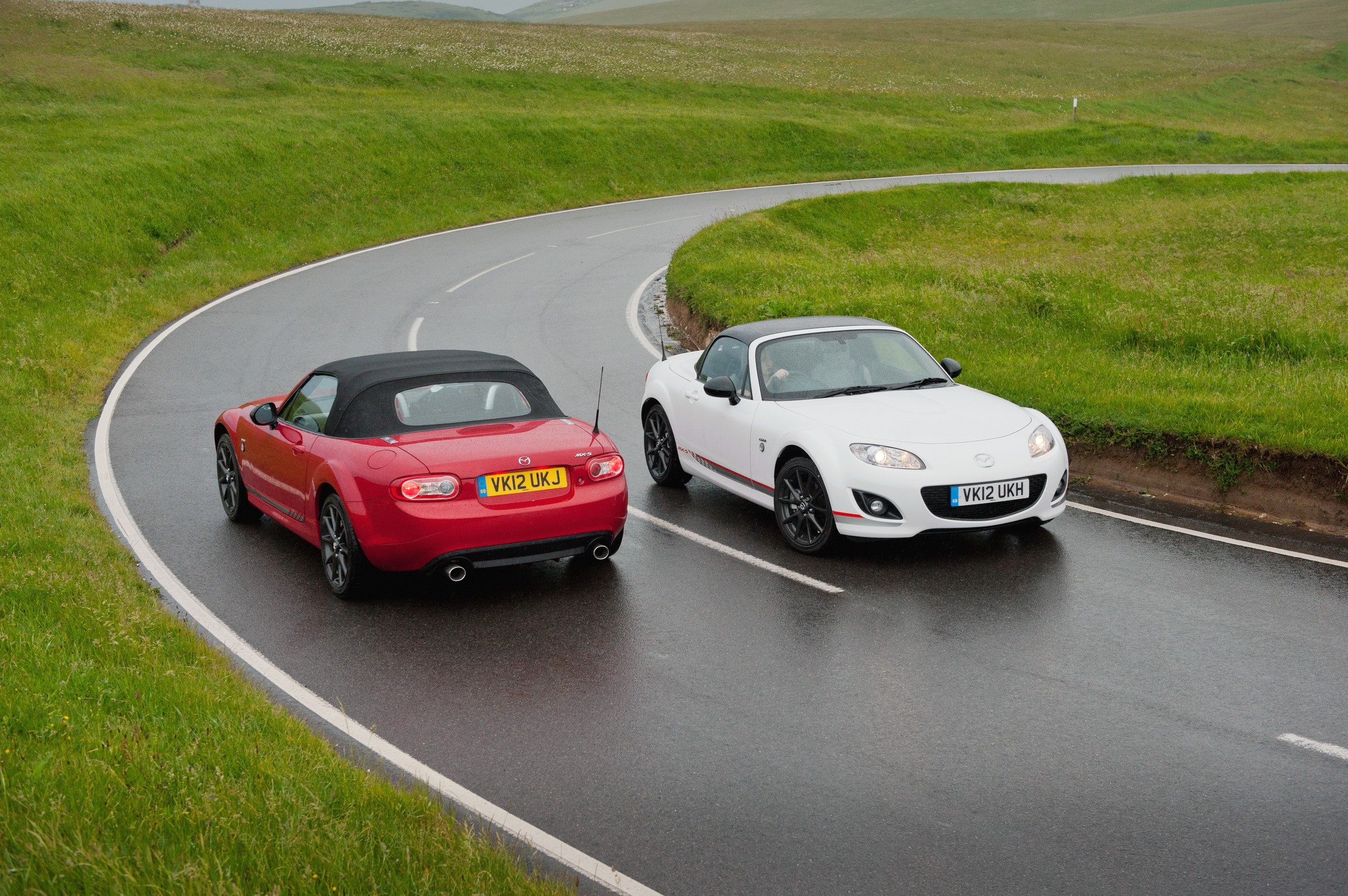 Two Mazda MX-5 convertibles on a wet road HD Wallpaper