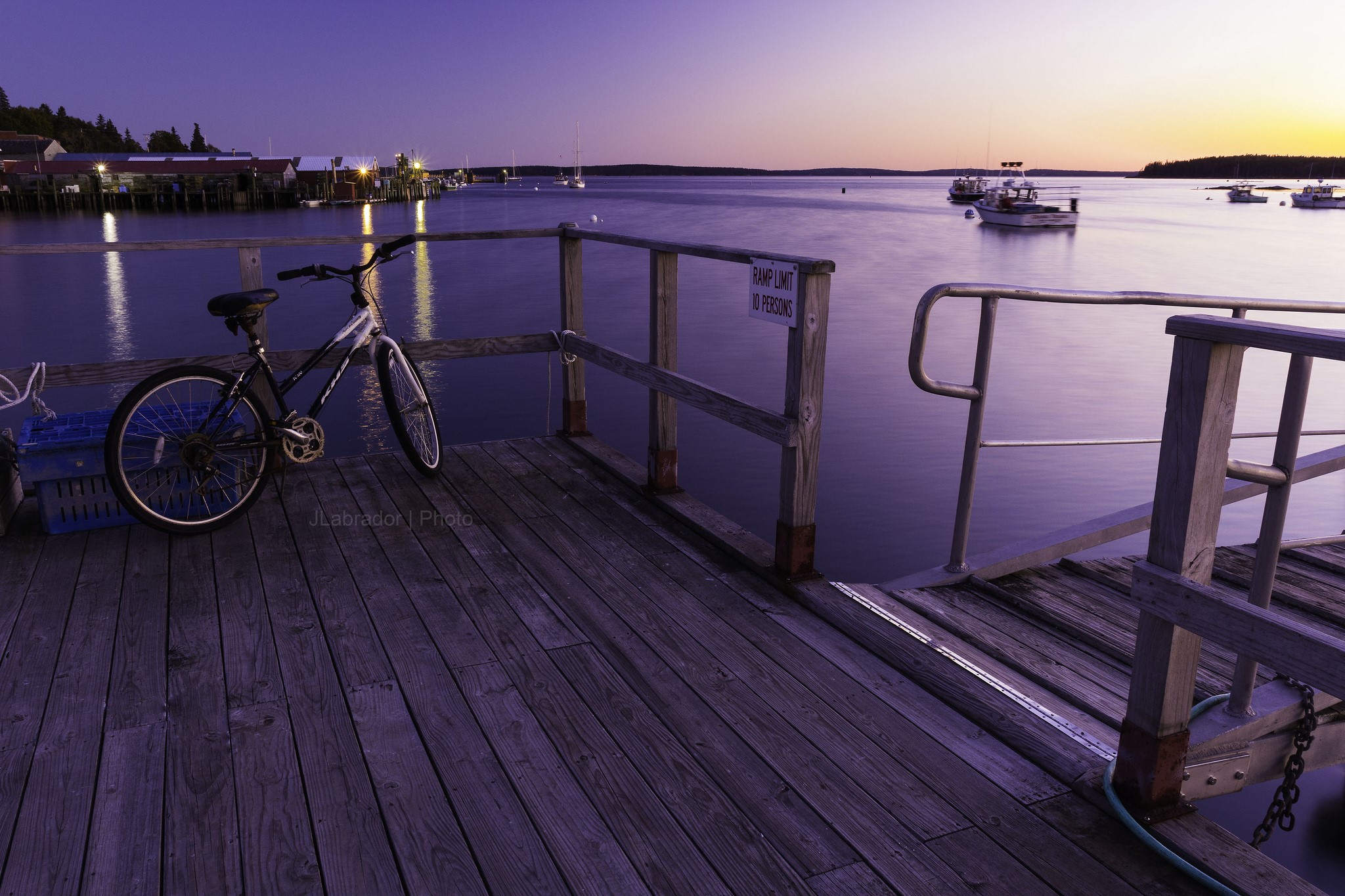 Bicycle on a dock at dusk with boats in the harbor HD Wallpaper