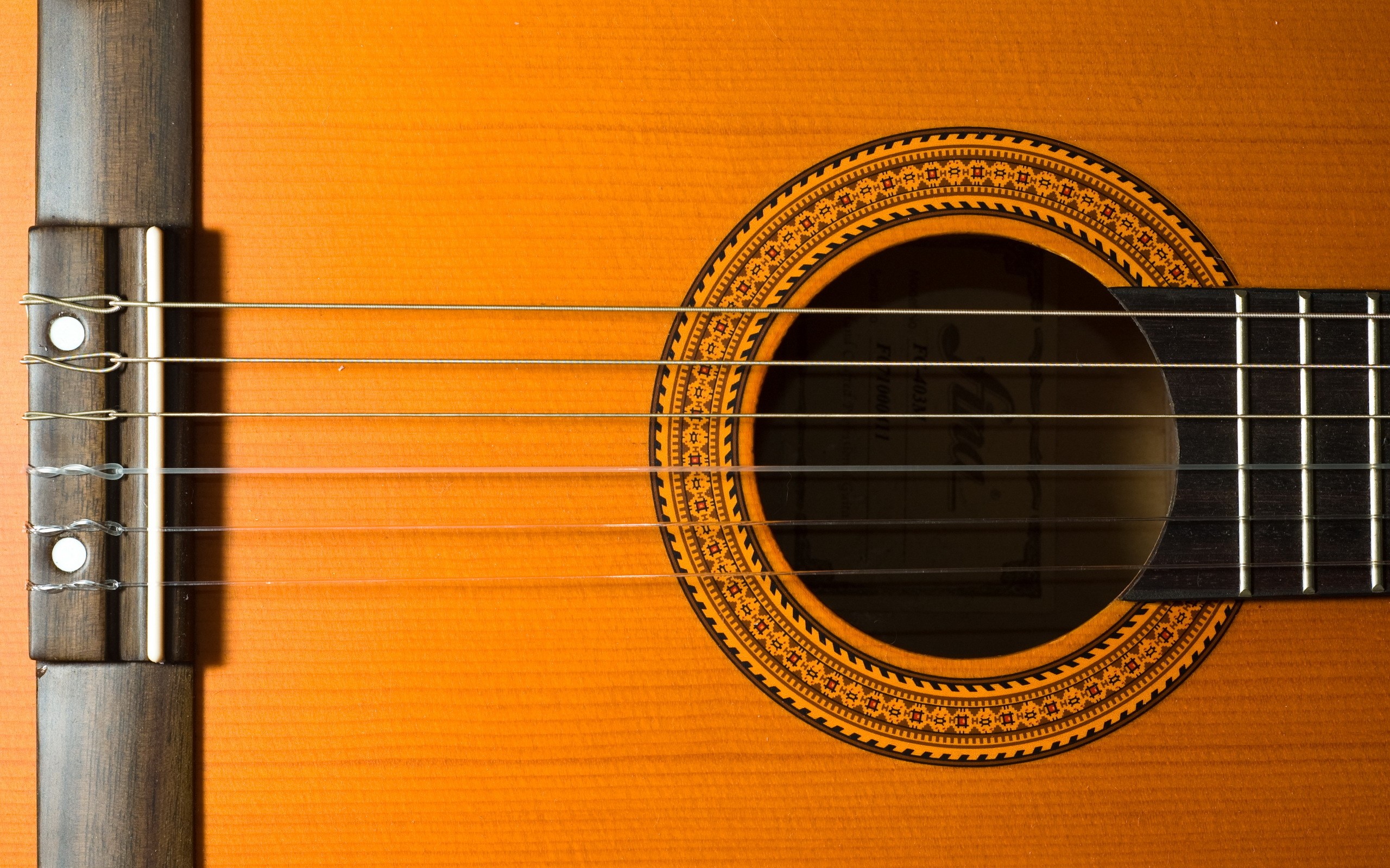 Closeup of a classical guitar's soundhole and strings HD Wallpaper