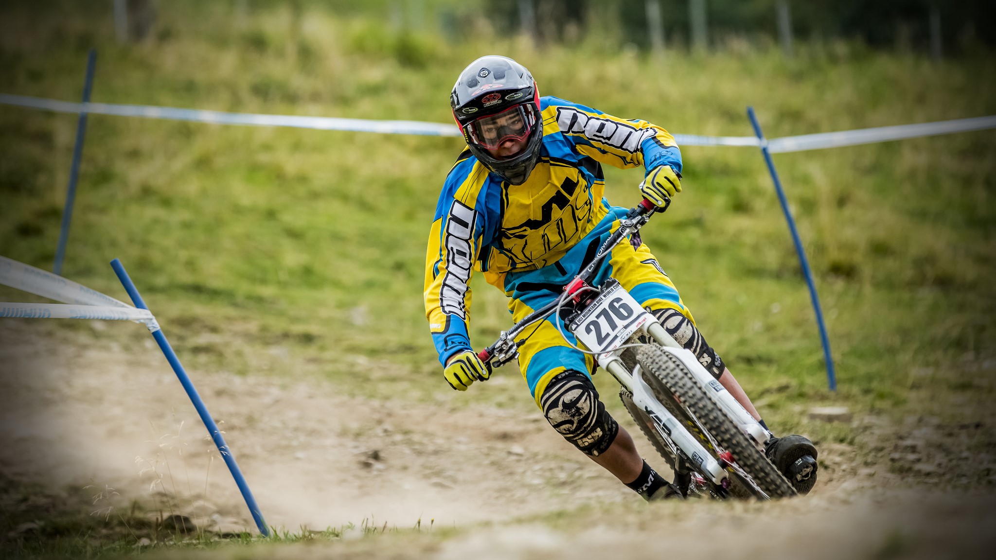 Downhill mountain biker in yellow and blue gear HD Wallpaper