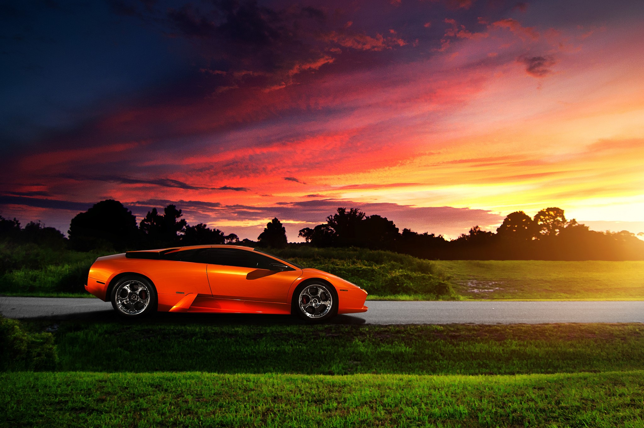 Orange Lamborghini on a road at sunset HD Wallpaper