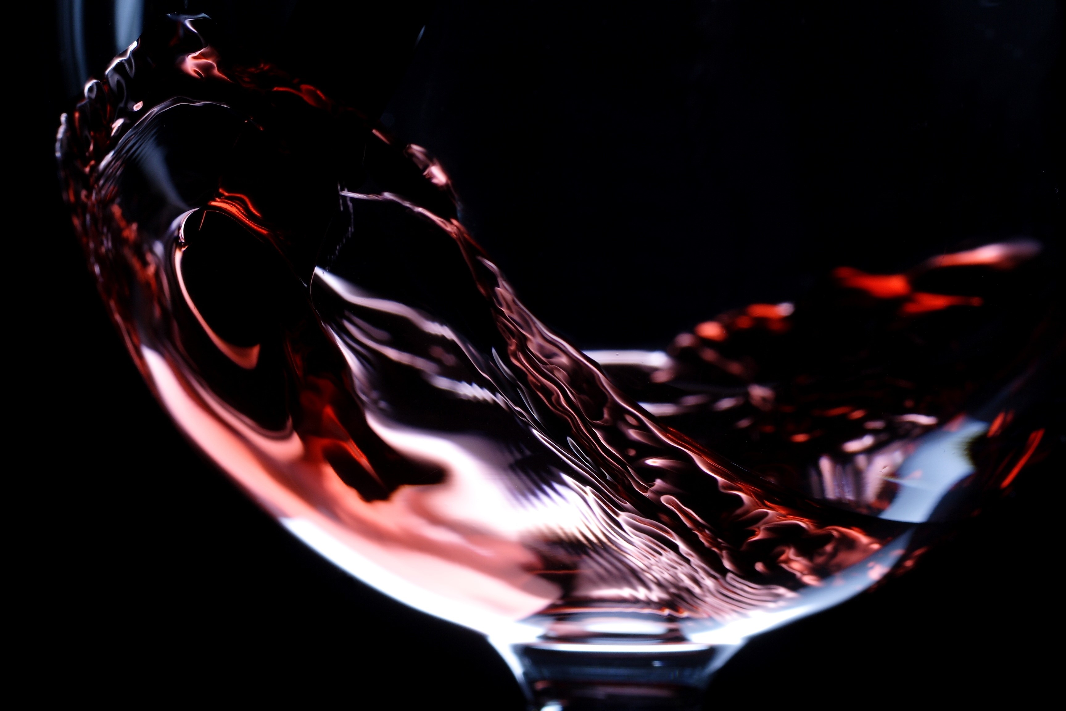Close-up of red wine swirling in a glass HD Wallpaper