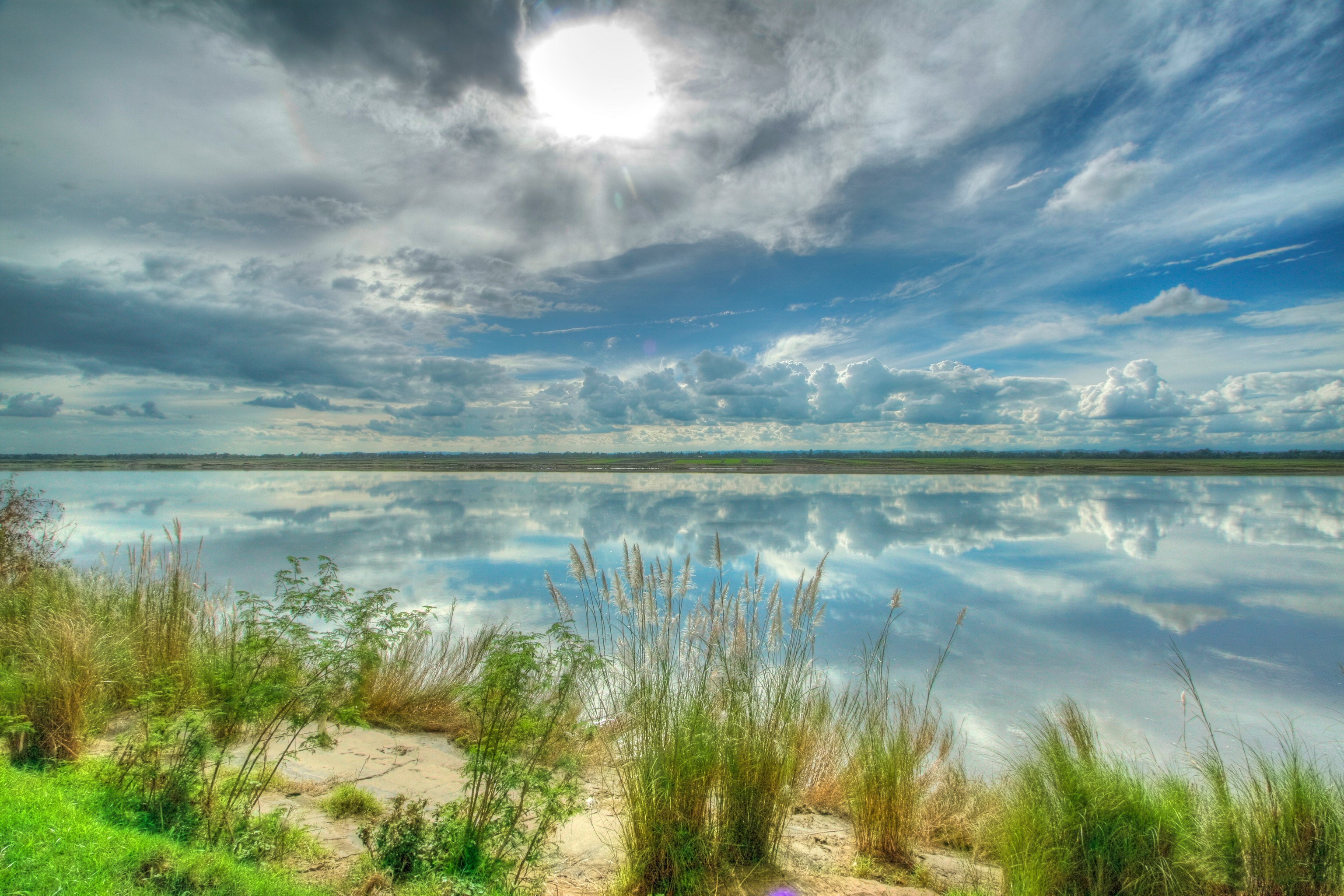 River reflecting clouds and sky with grass on the bank HD Wallpaper