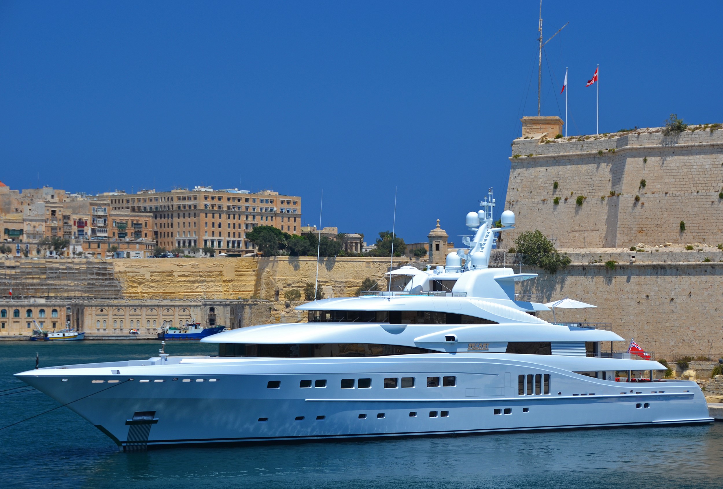 Luxury Yacht docked near historic fortifications HD Wallpaper