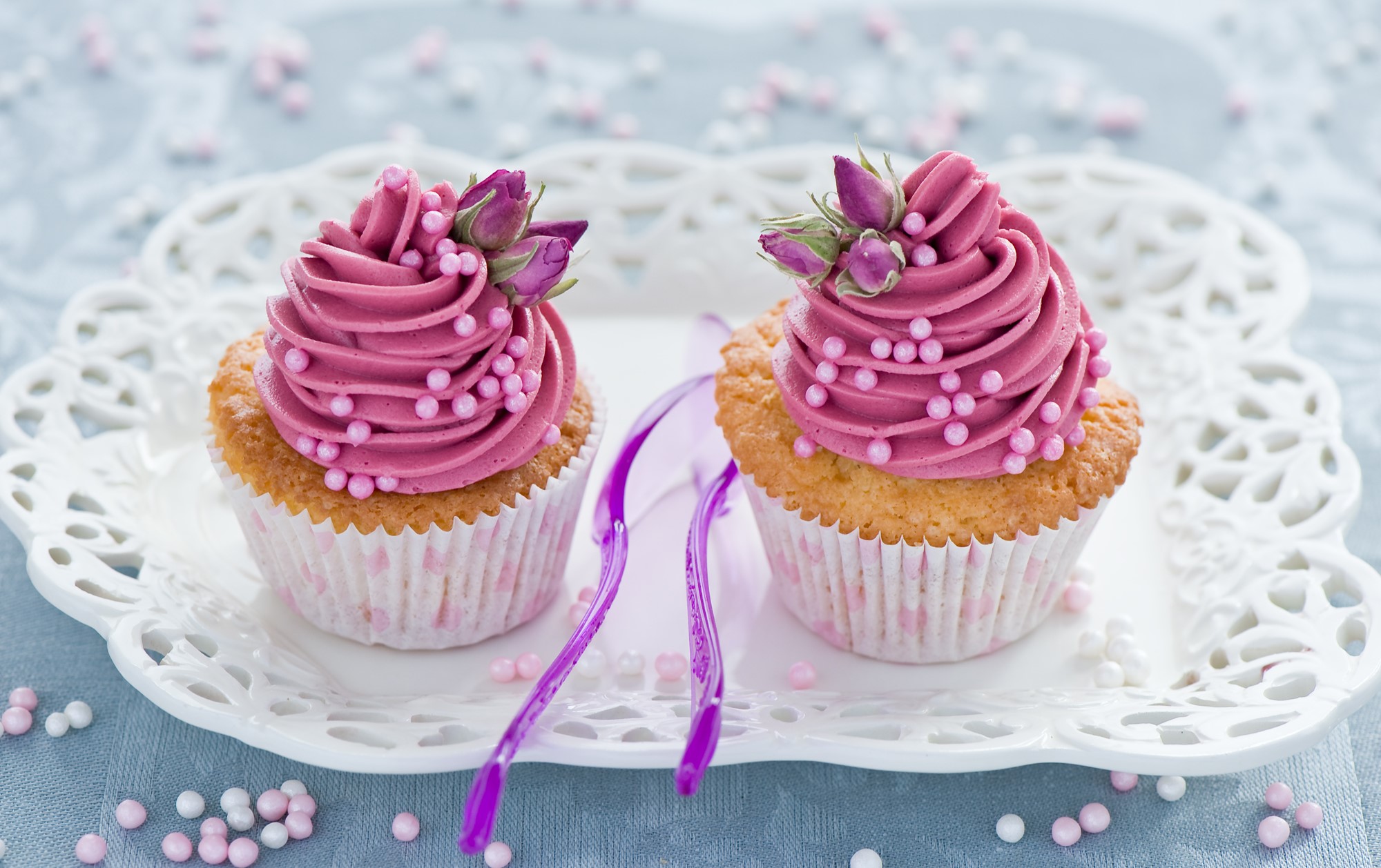 Two pink frosted cupcakes with rose buds and sprinkles HD Wallpaper