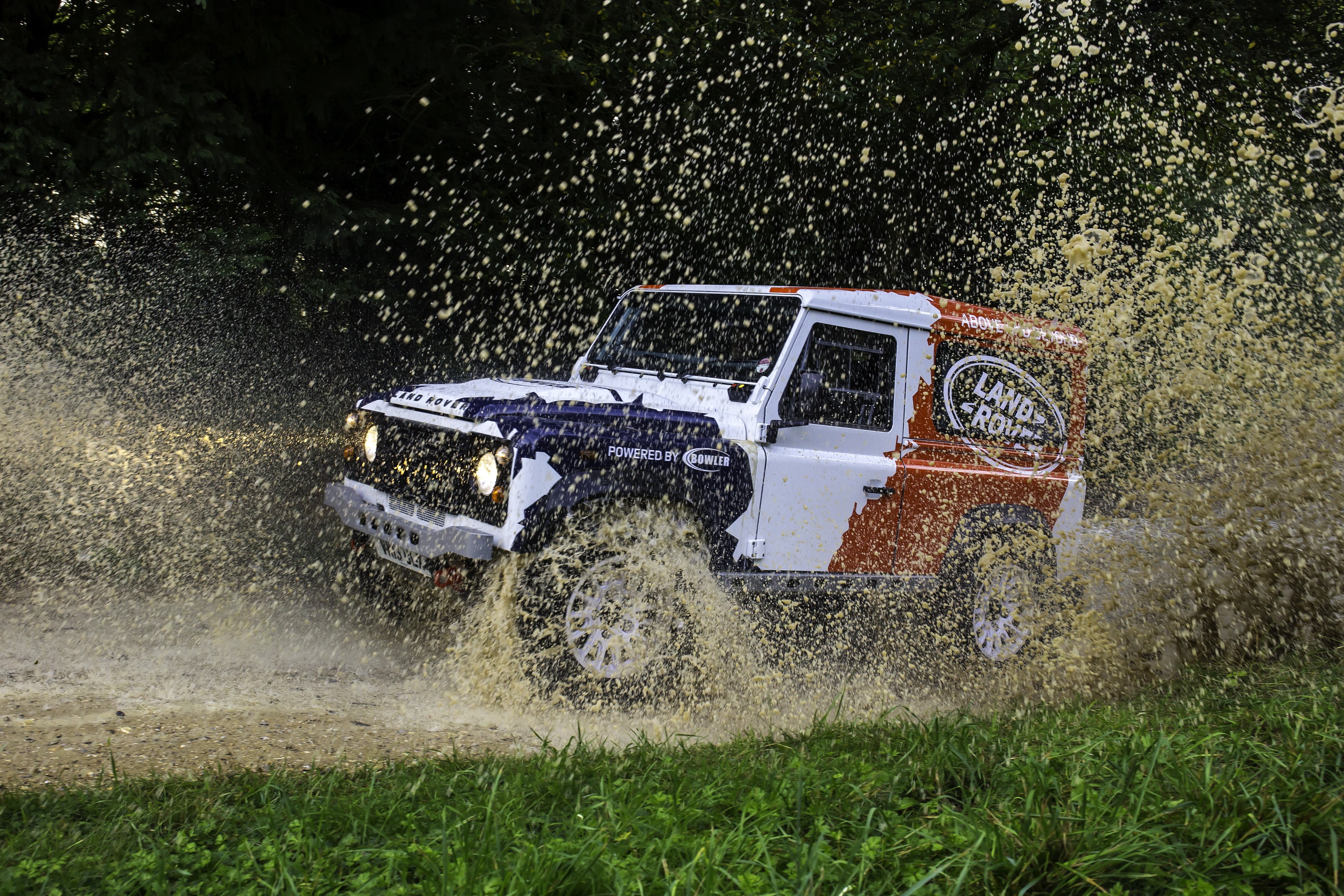 Land Rover Defender Challenge driving through water splash HD Wallpaper