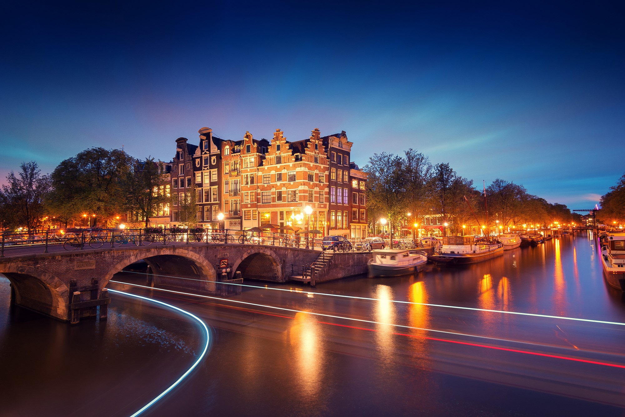 Amsterdam canal at night with bridge and boats HD Wallpaper