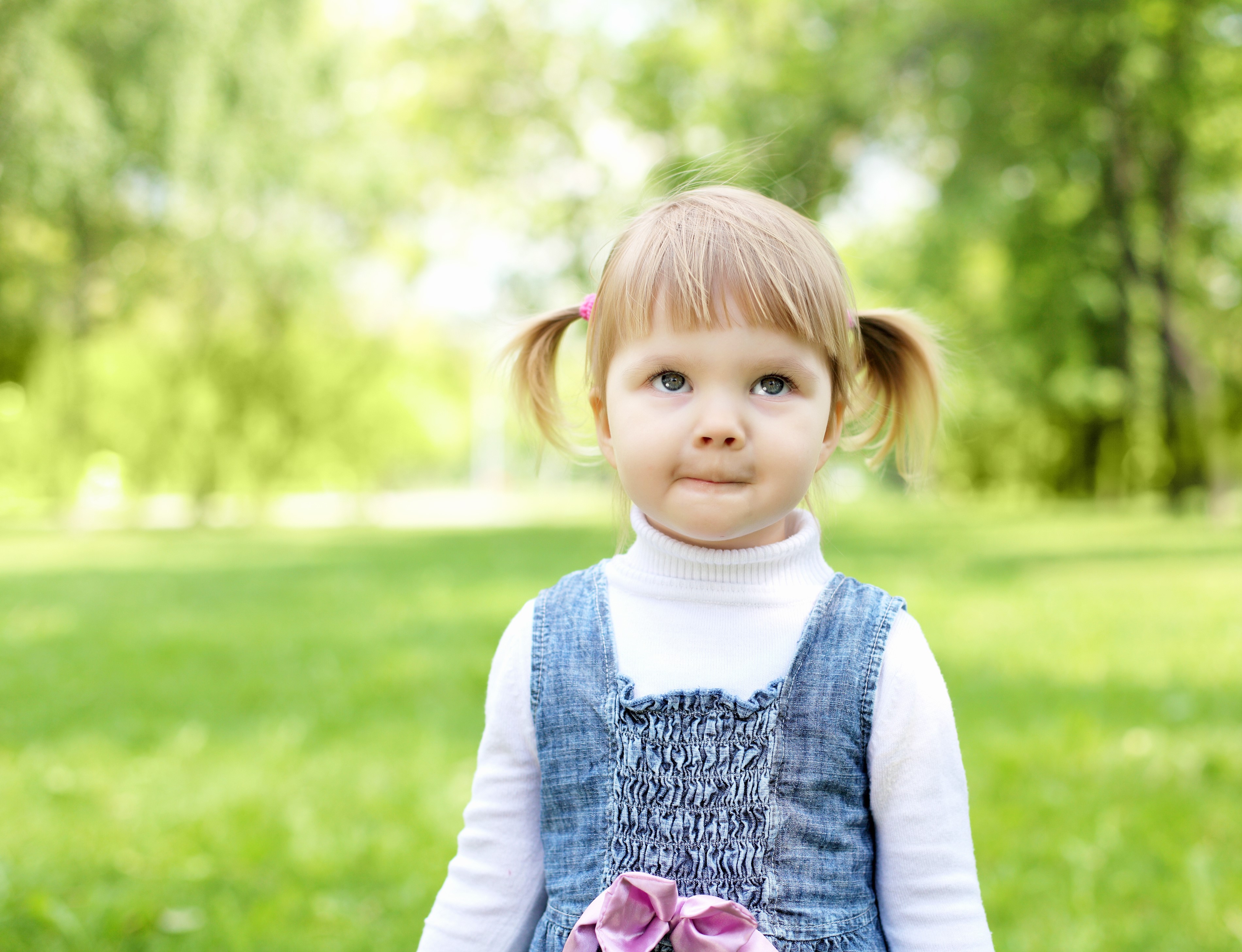 Little girl with pigtails in a park HD Wallpaper