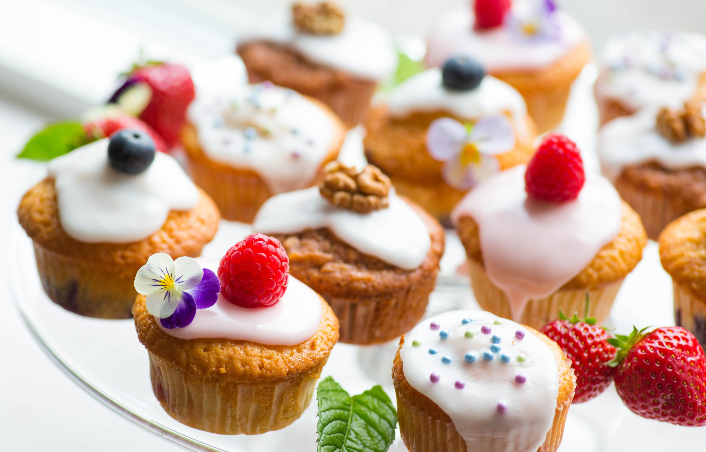 Assortment of decorated cupcakes on a glass stand HD Wallpaper