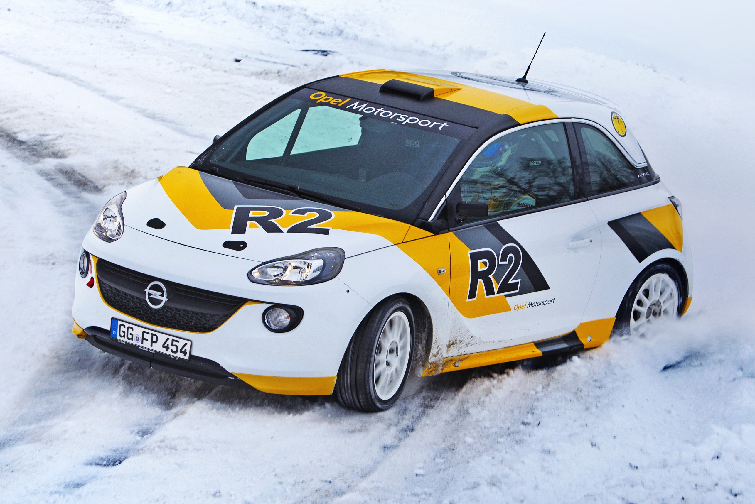 Opel Adam R2 rally car driving in snow HD Wallpaper
