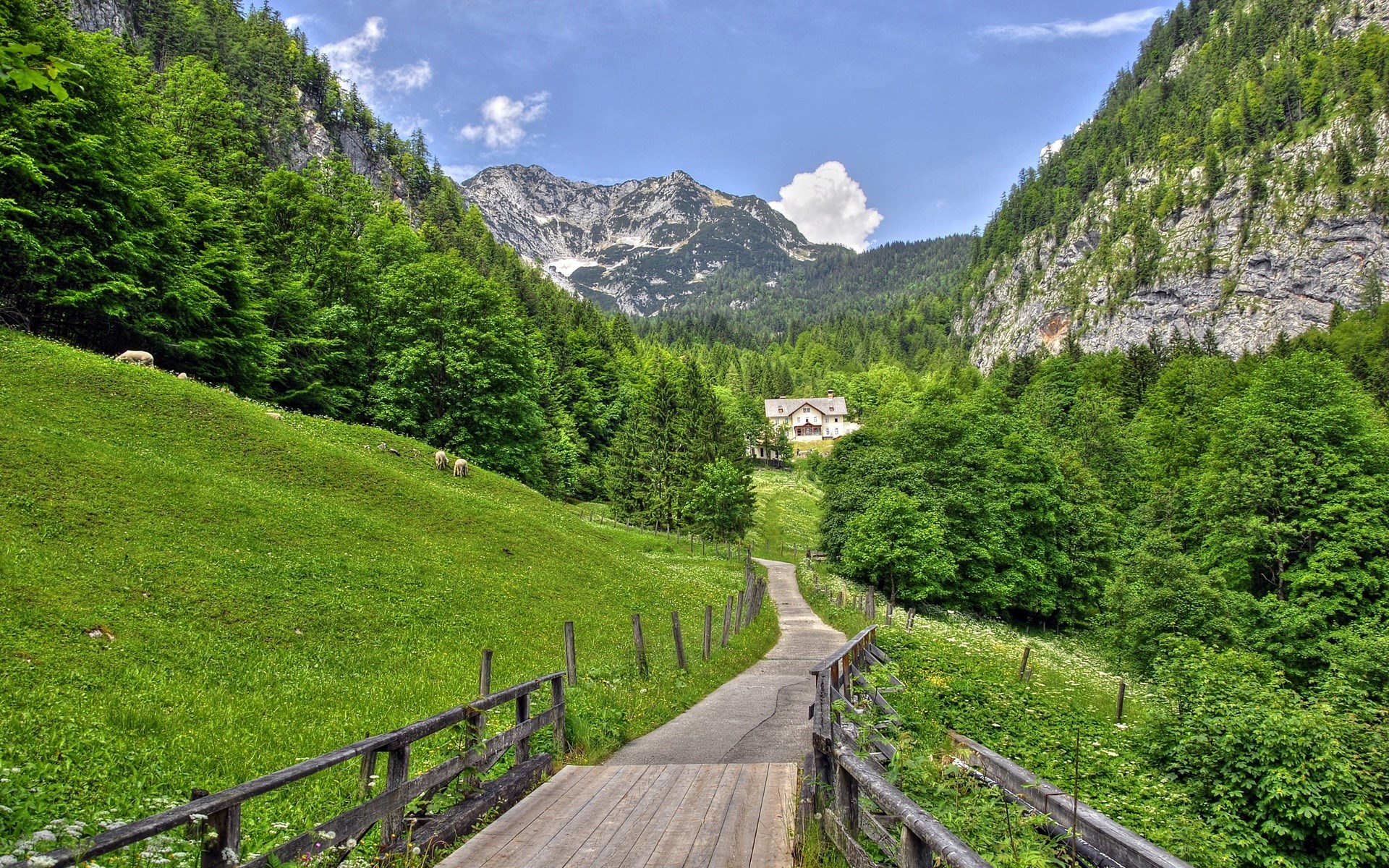 A scenic mountain valley with a house and a road HD Wallpaper