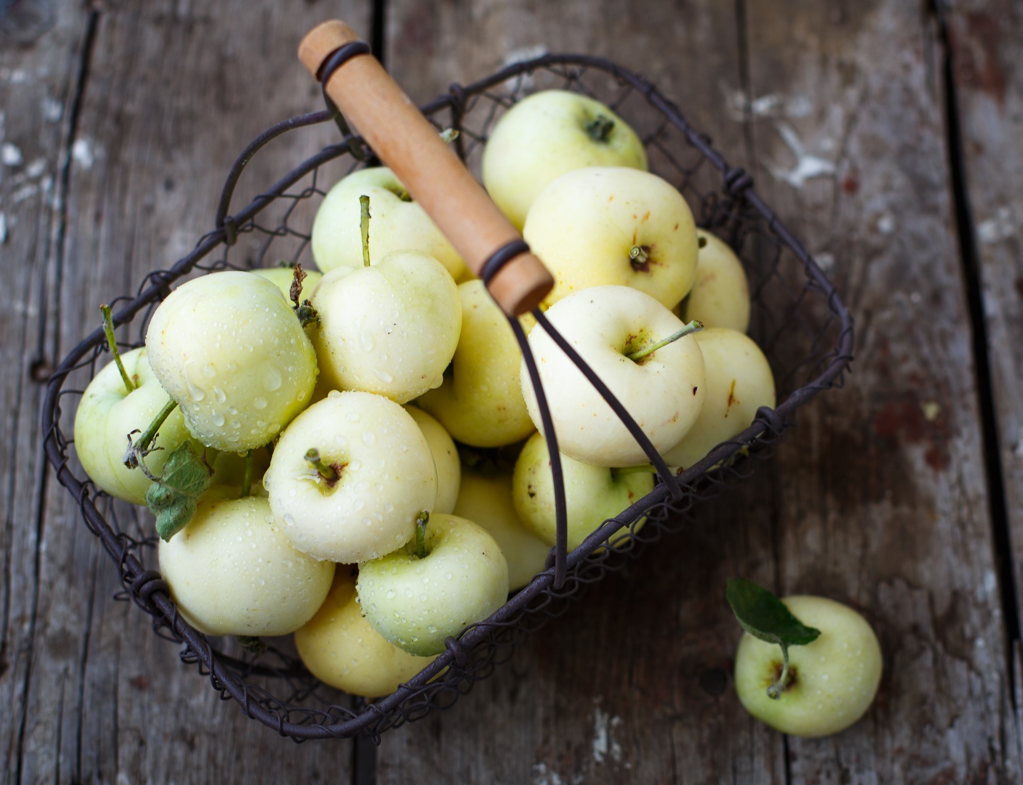 Basket of fresh apples on a wooden table HD Wallpaper
