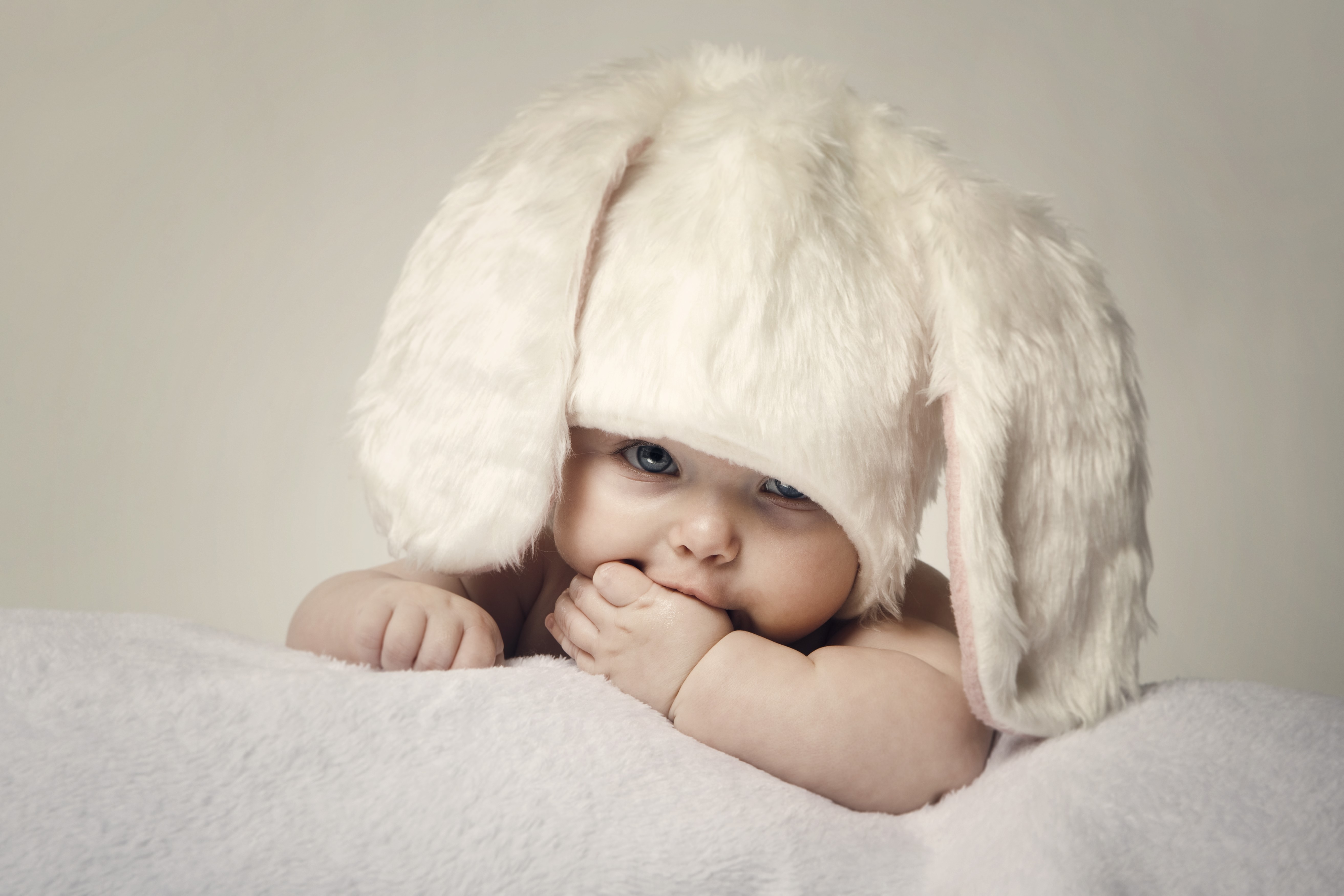 Baby wearing a fluffy bunny hat HD Wallpaper
