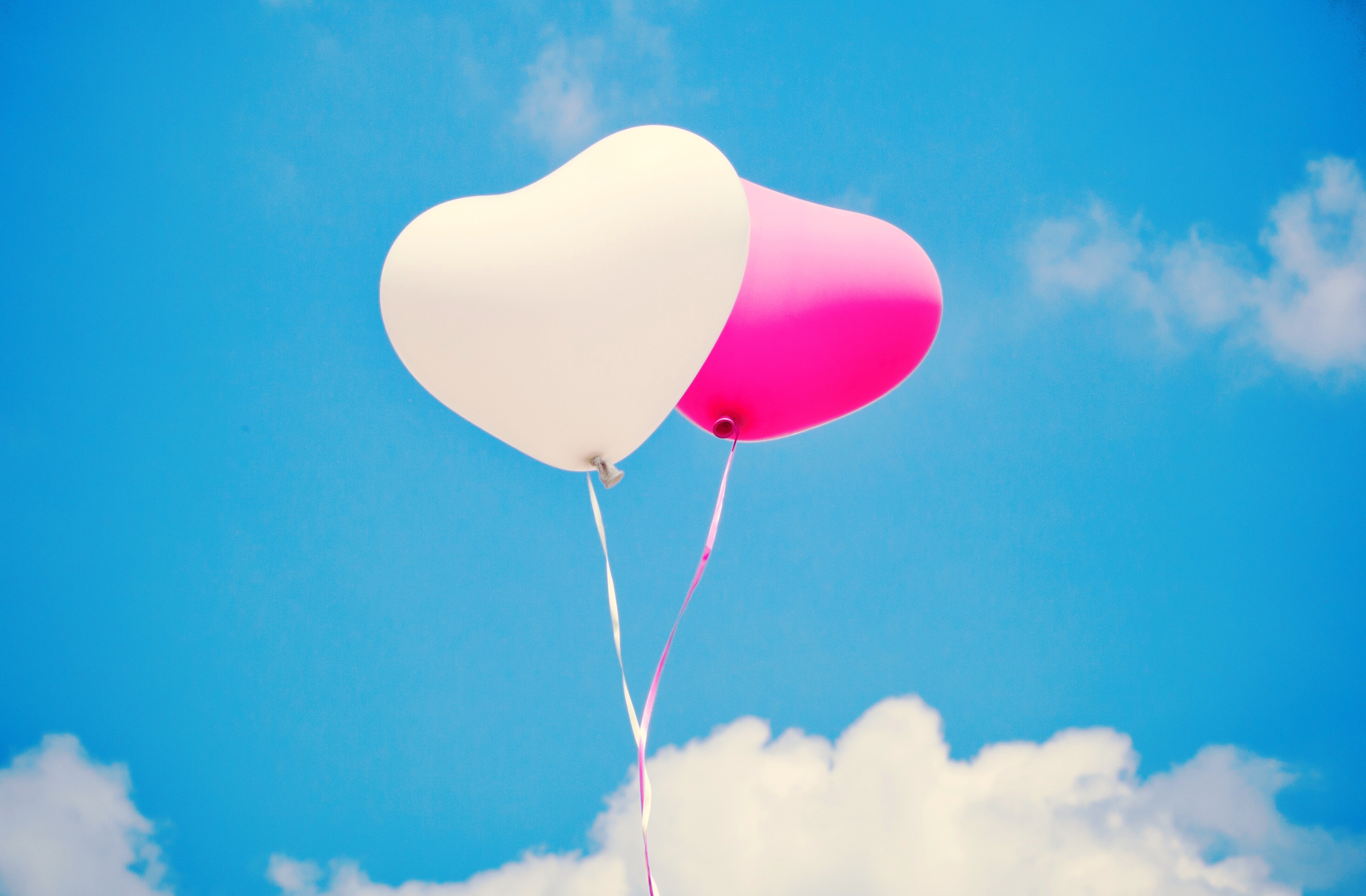 Two heart-shaped balloons in the sky HD Wallpaper