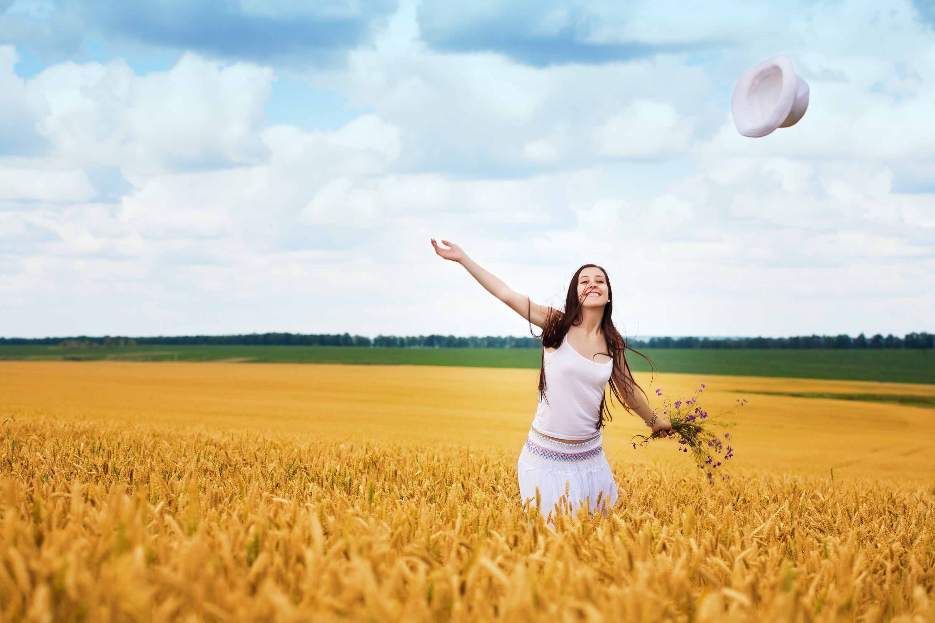 Woman in a wheat field throwing her hat HD Wallpaper