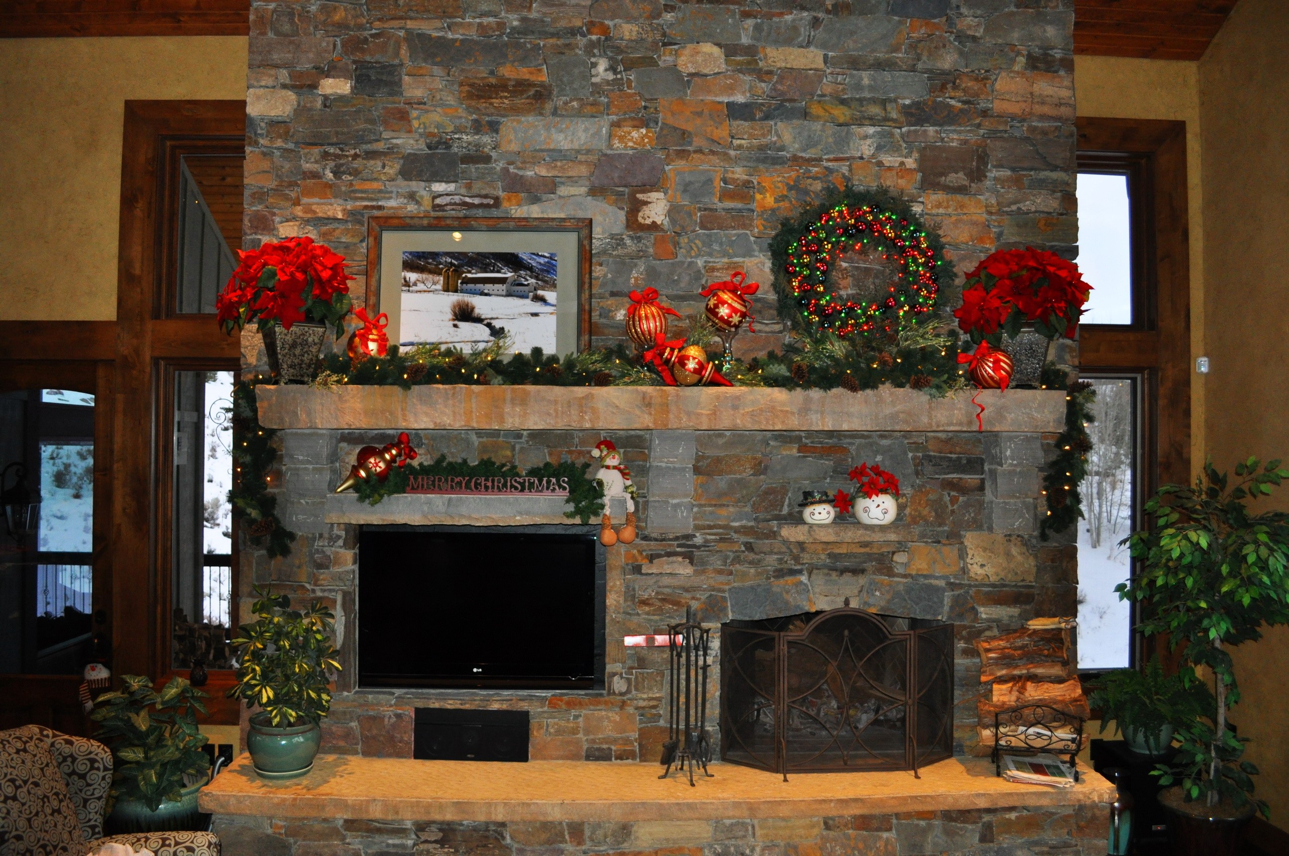 Christmas decorated fireplace with poinsettias and wreath HD Wallpaper