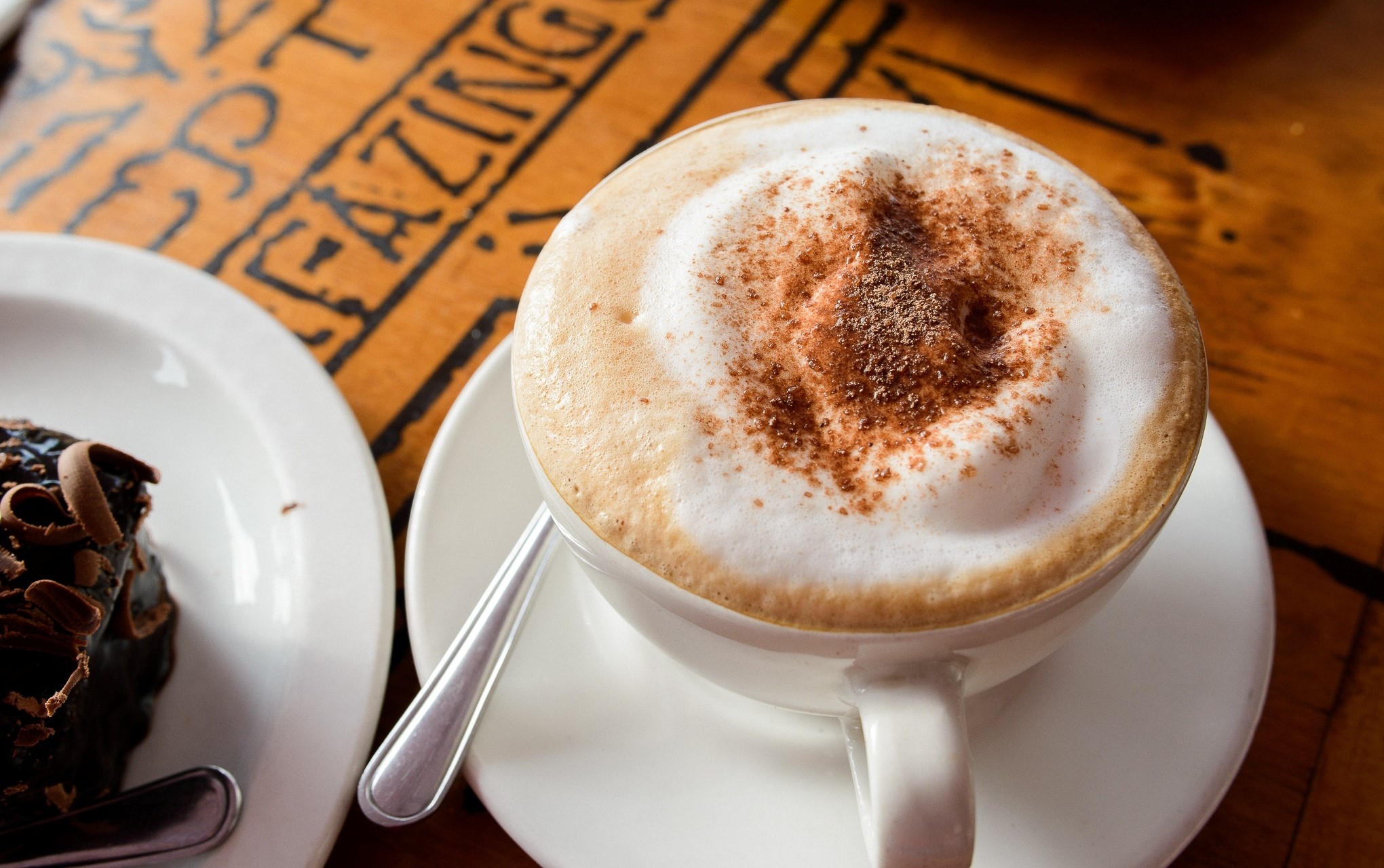 Cappuccino and chocolate cake on a wooden table HD Wallpaper