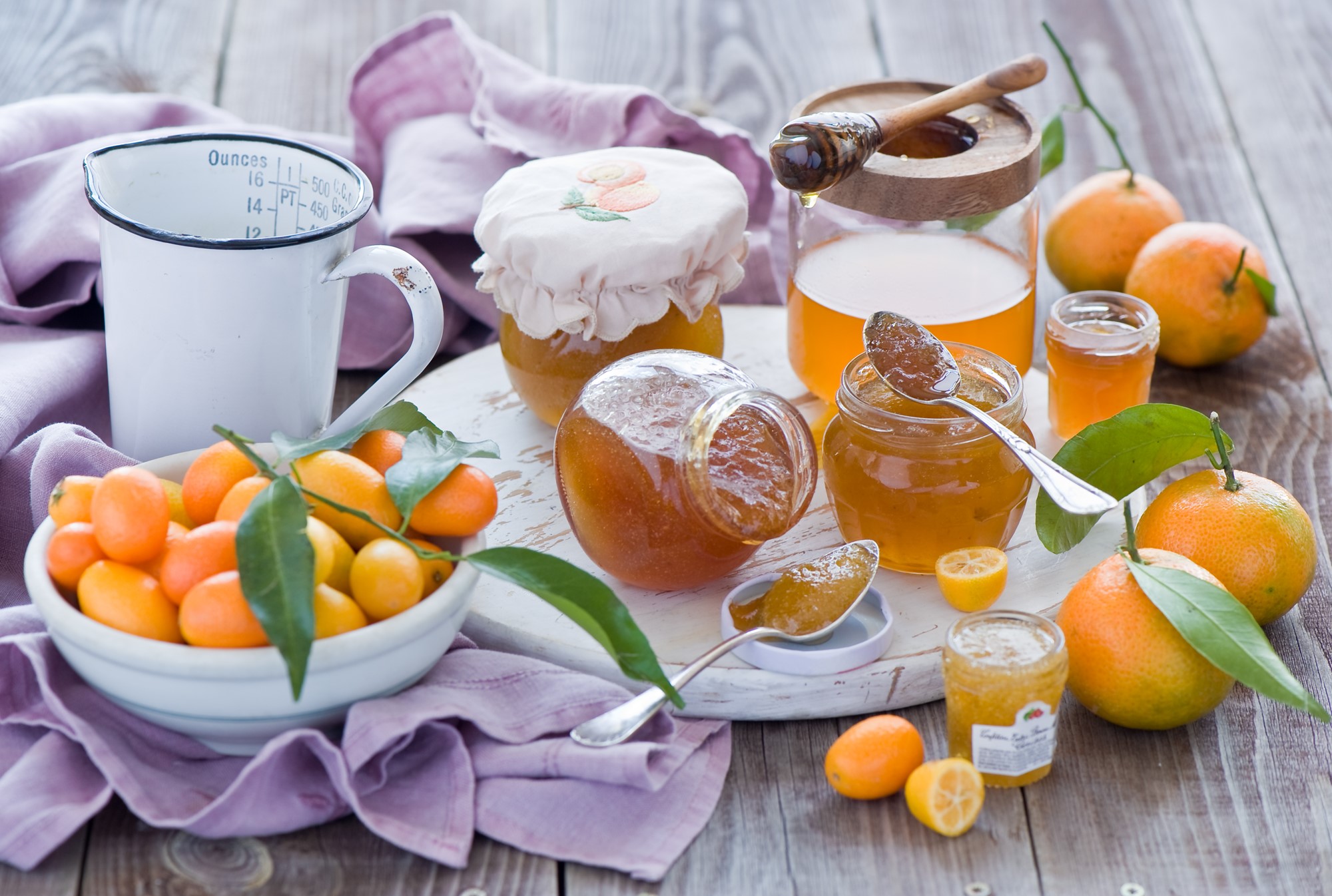 Jars of honey and kumquats with a measuring cup HD Wallpaper