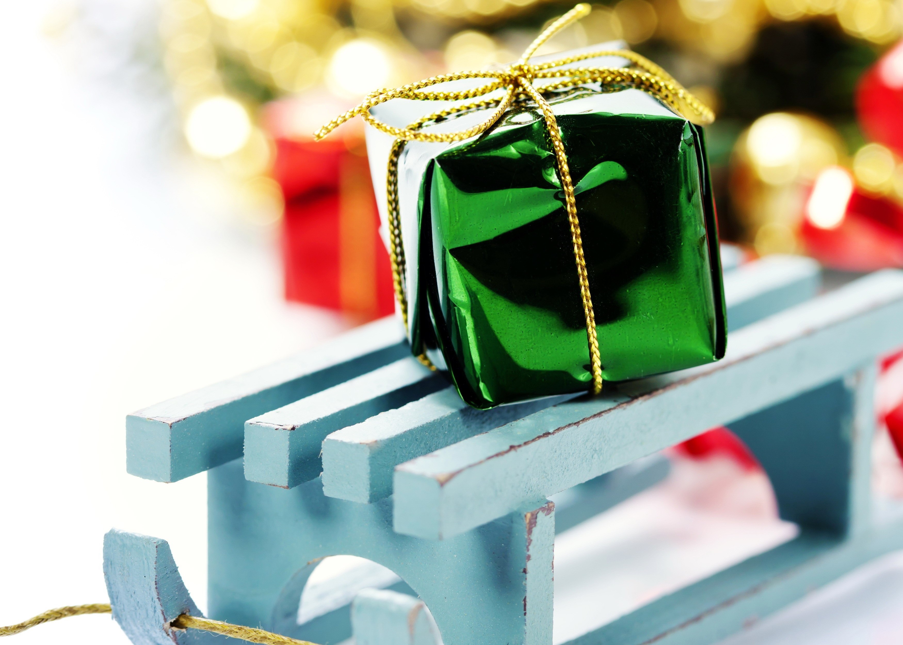 Green gift on a blue sled with Christmas decorations HD Wallpaper