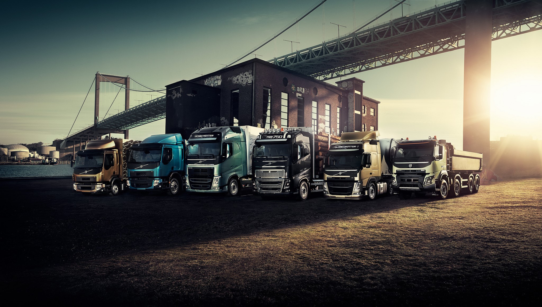 Volvo Trucks lined up under a bridge HD Wallpaper