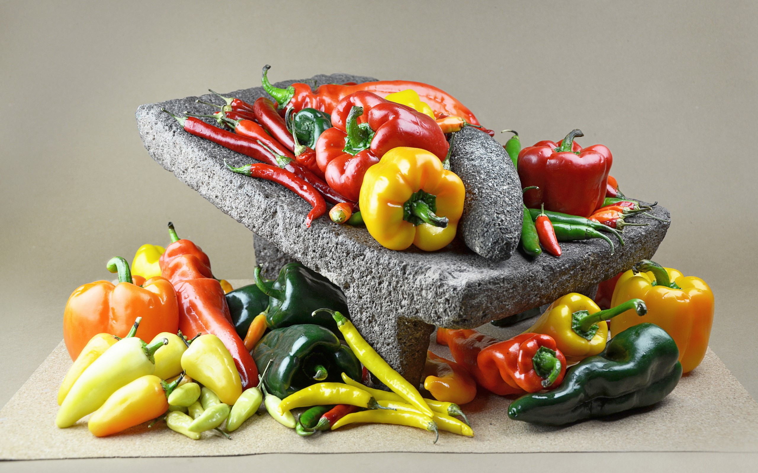 Assortment of colorful peppers and chilies in a stone molcajete HD Wallpaper