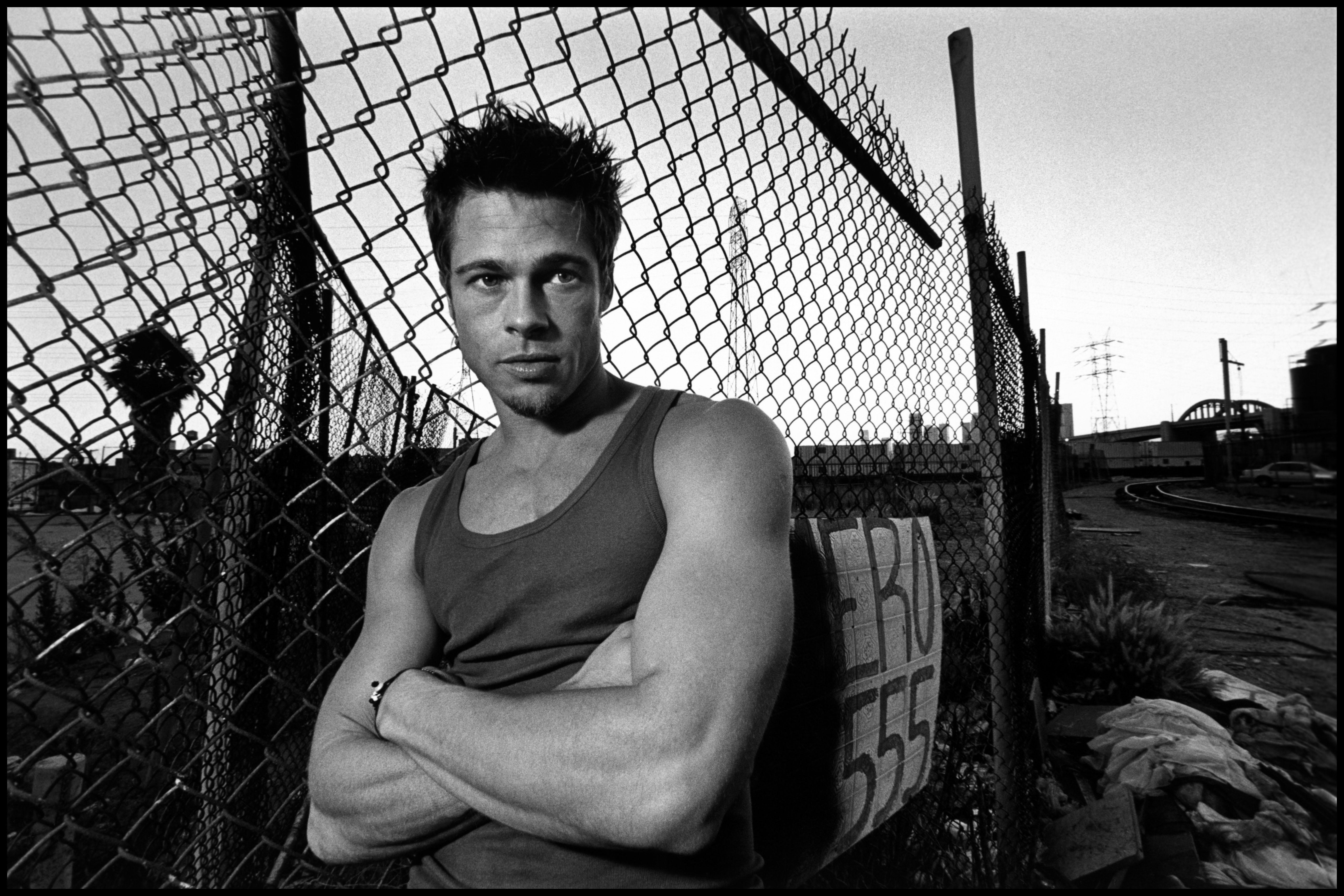 Brad Pitt in a singlet by a fence HD Wallpaper