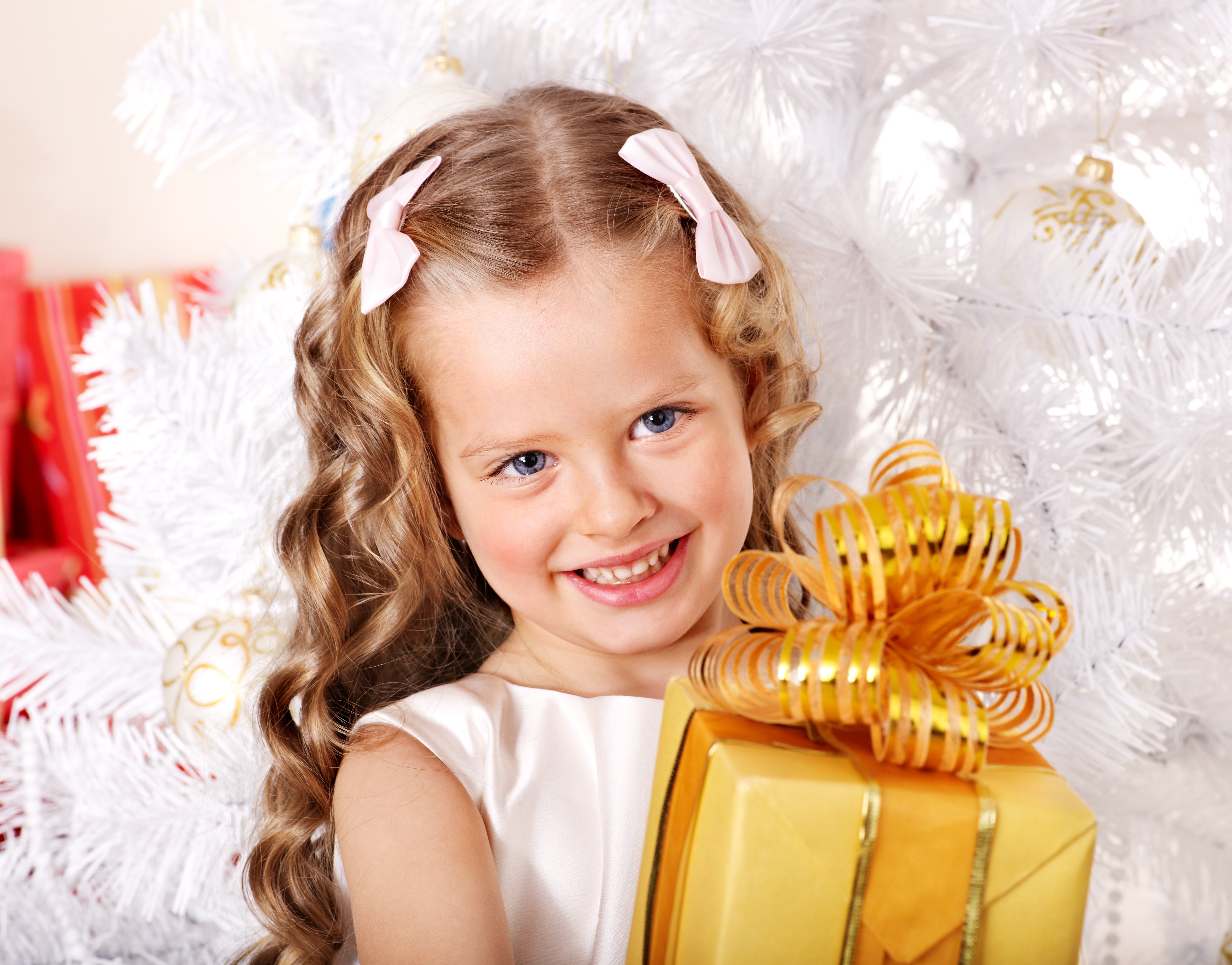 Little girl with gift near Christmas tree HD Wallpaper