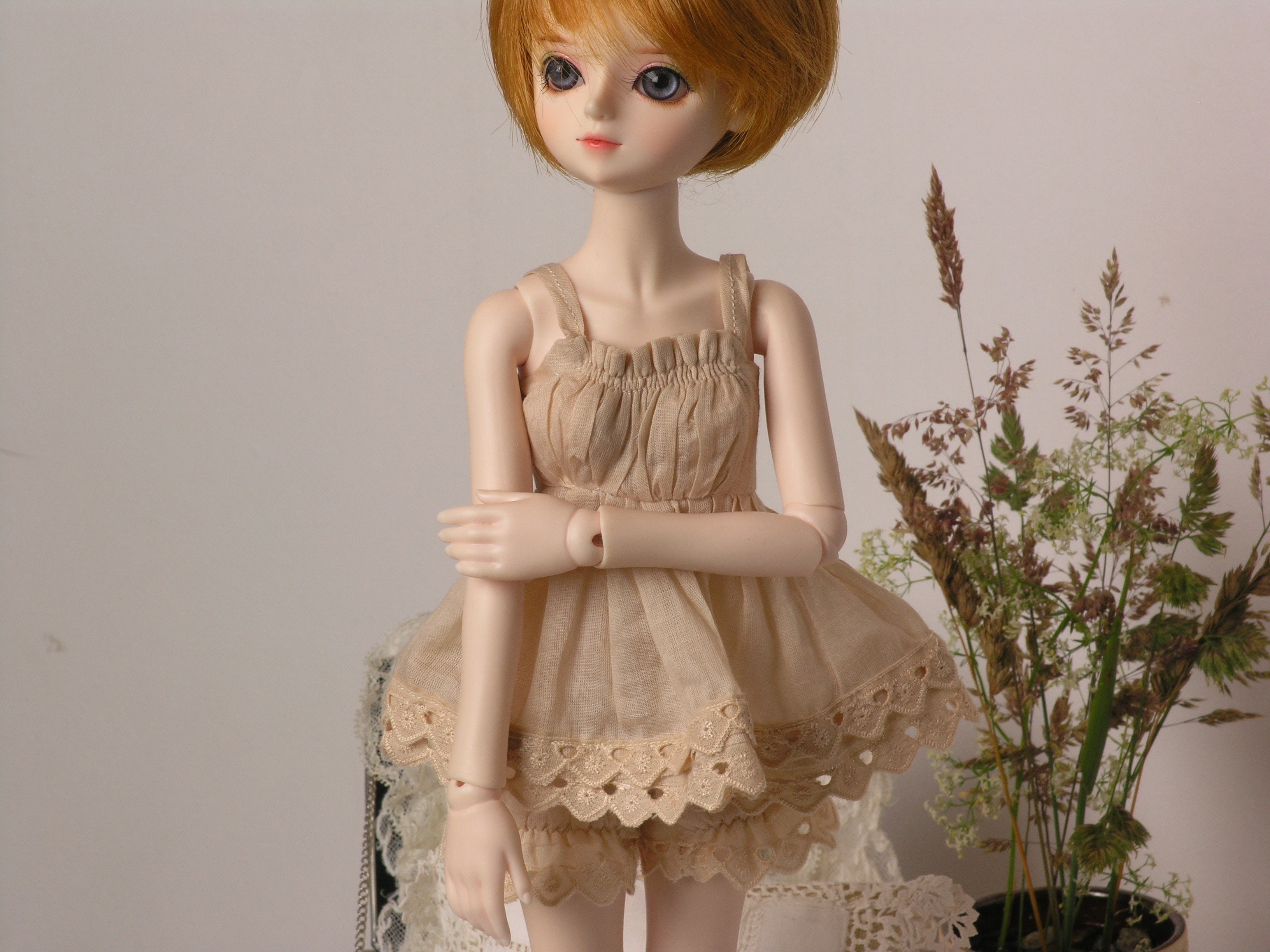 Doll wearing a beige dress with lace trim HD Wallpaper