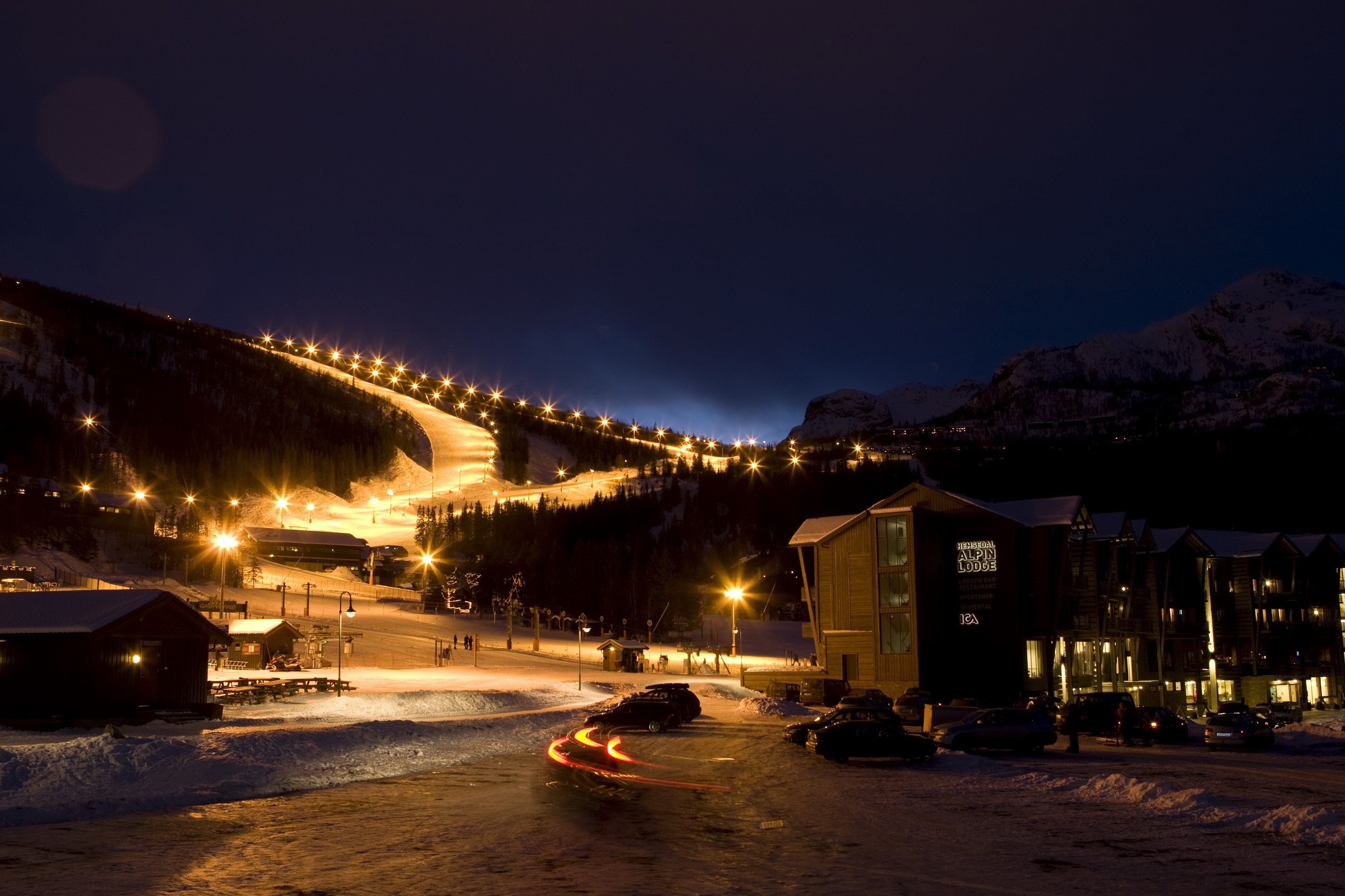 Ski resort at night with lights and buildings HD Wallpaper