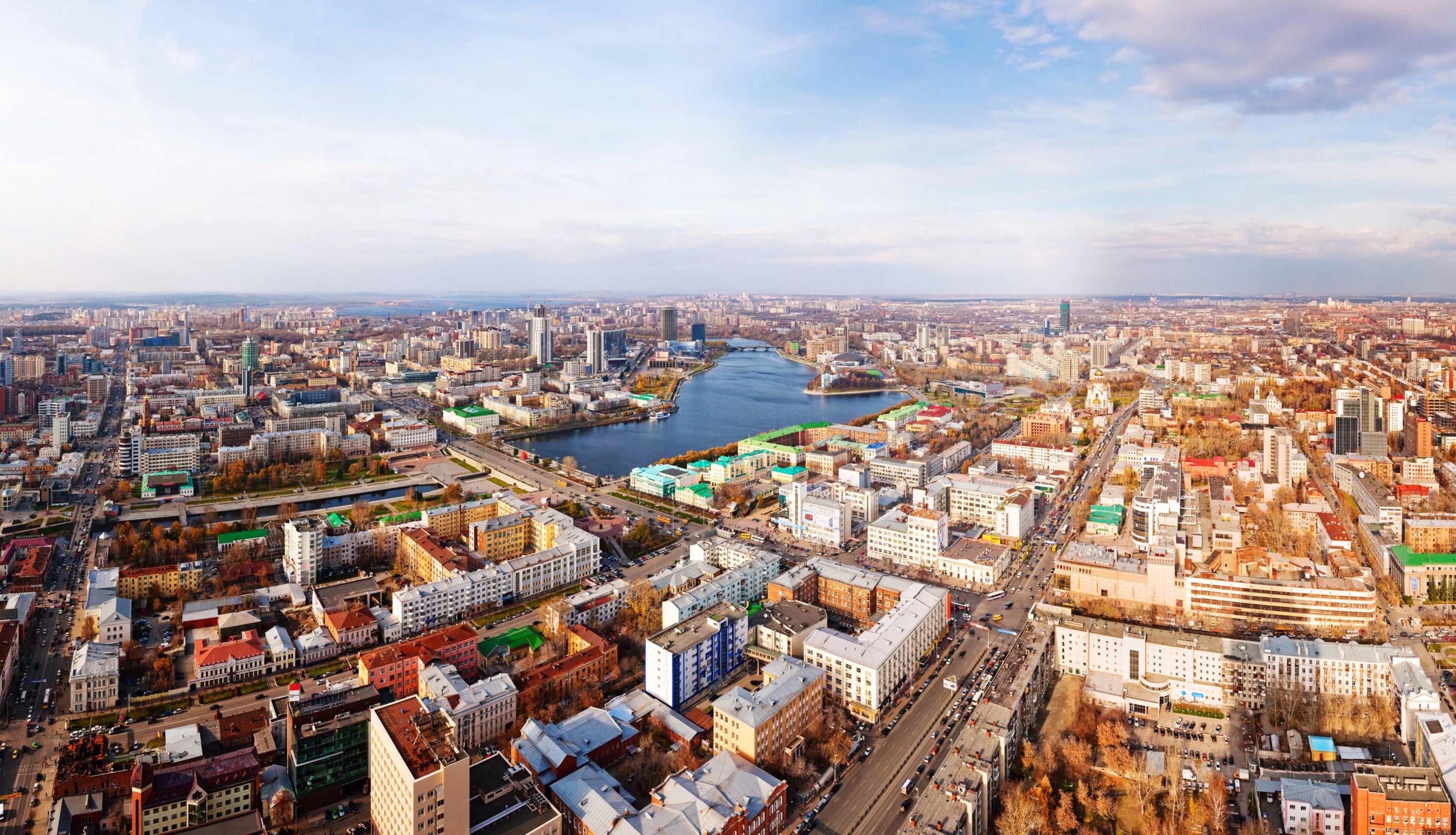 Aerial view of a city with a river and buildings HD Wallpaper