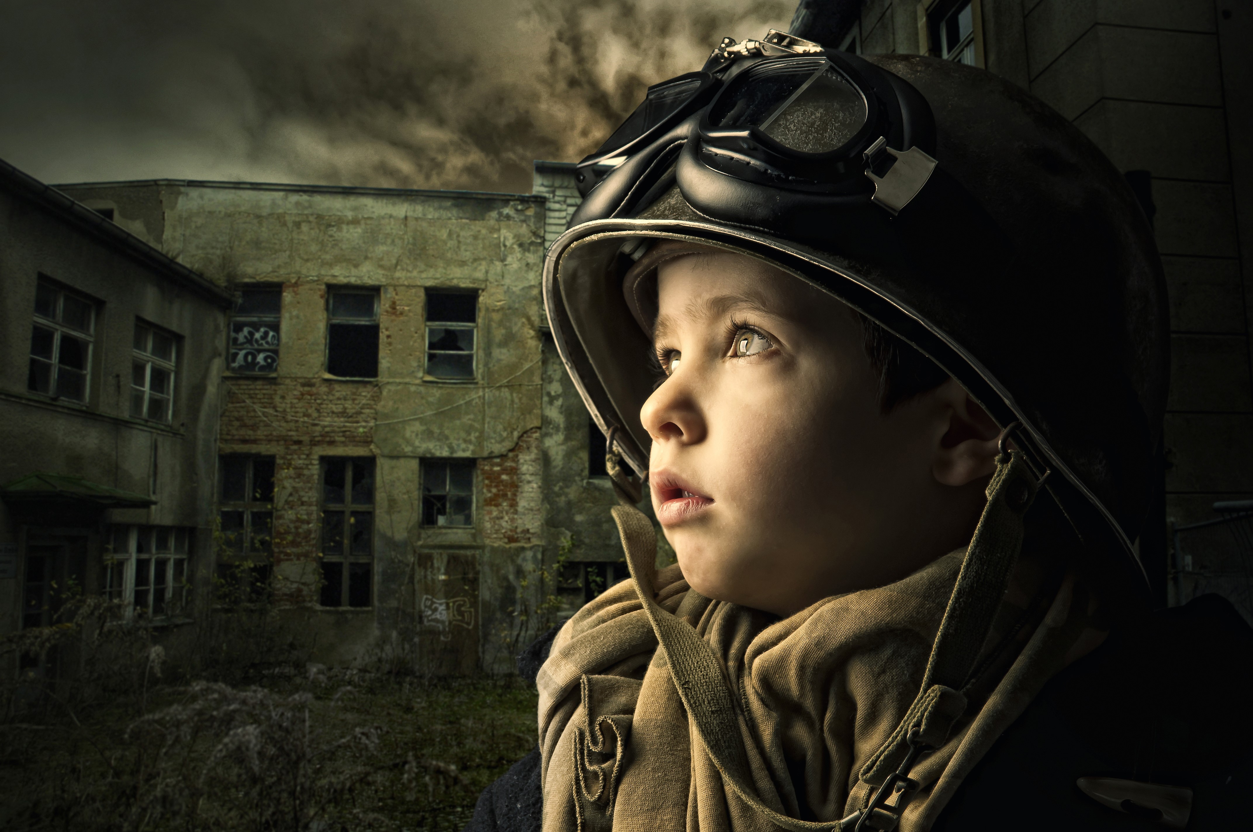 Boy in Helmet and Goggles in War-Torn City HD Wallpaper