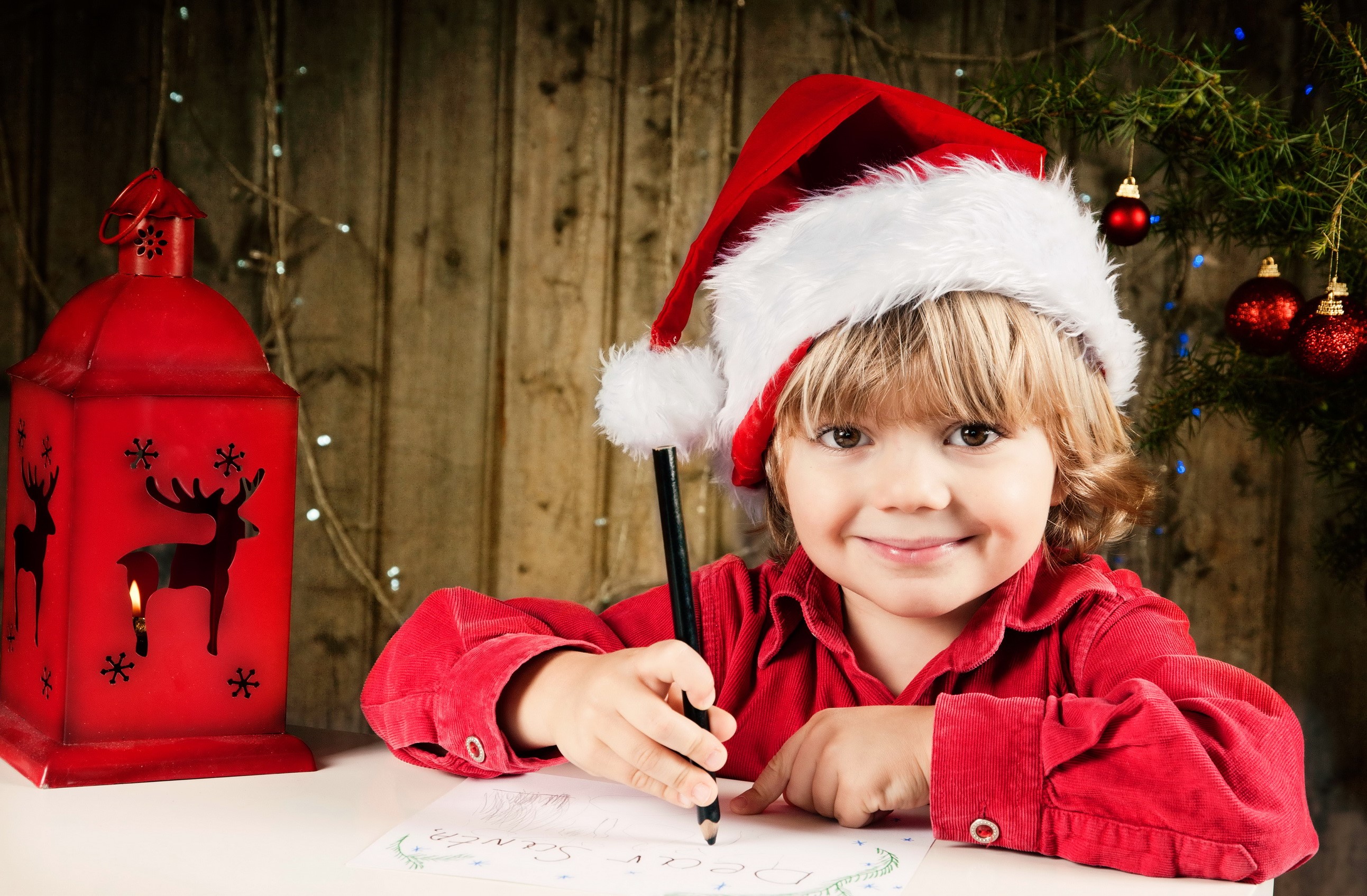 Boy in Santa hat writing a letter to Santa HD Wallpaper