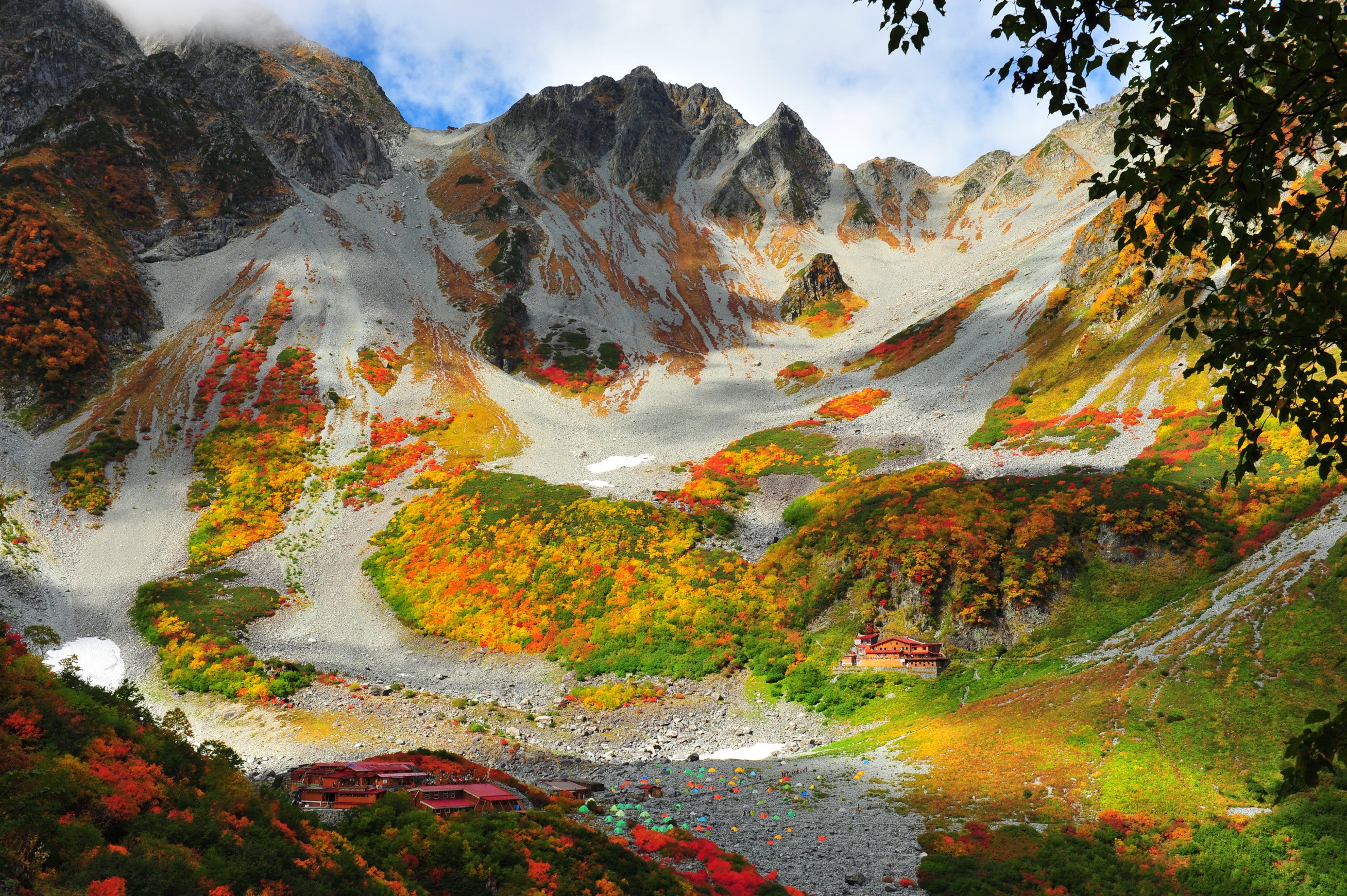 Autumn foliage in a mountain valley with lodges HD Wallpaper