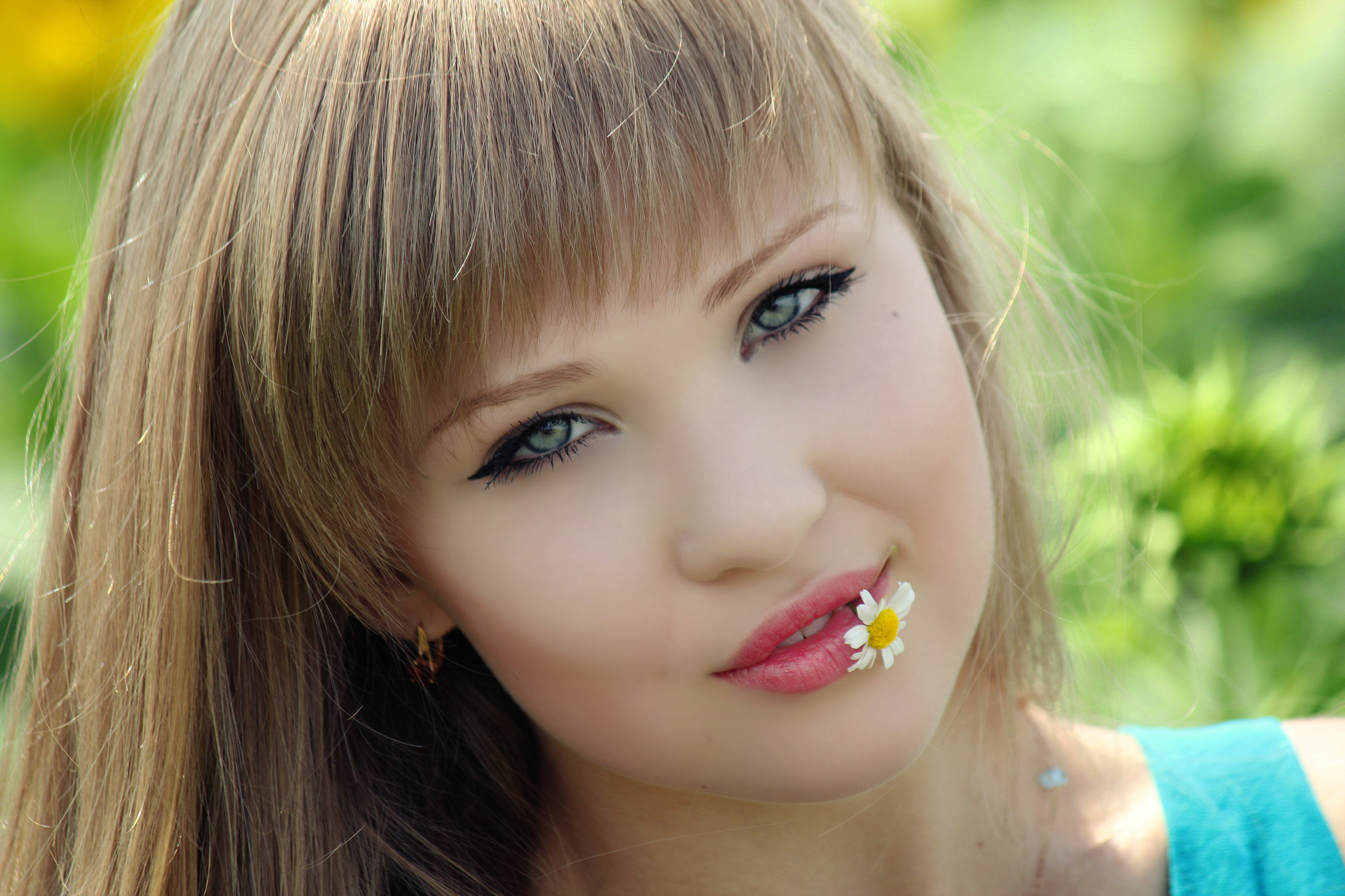 Young woman with a daisy in her mouth HD Wallpaper