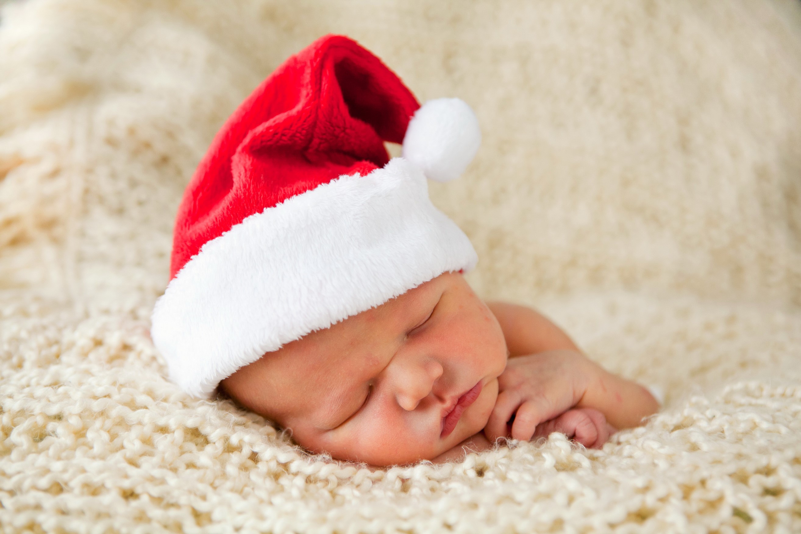 Baby wearing a Santa hat sleeping on a blanket HD Wallpaper