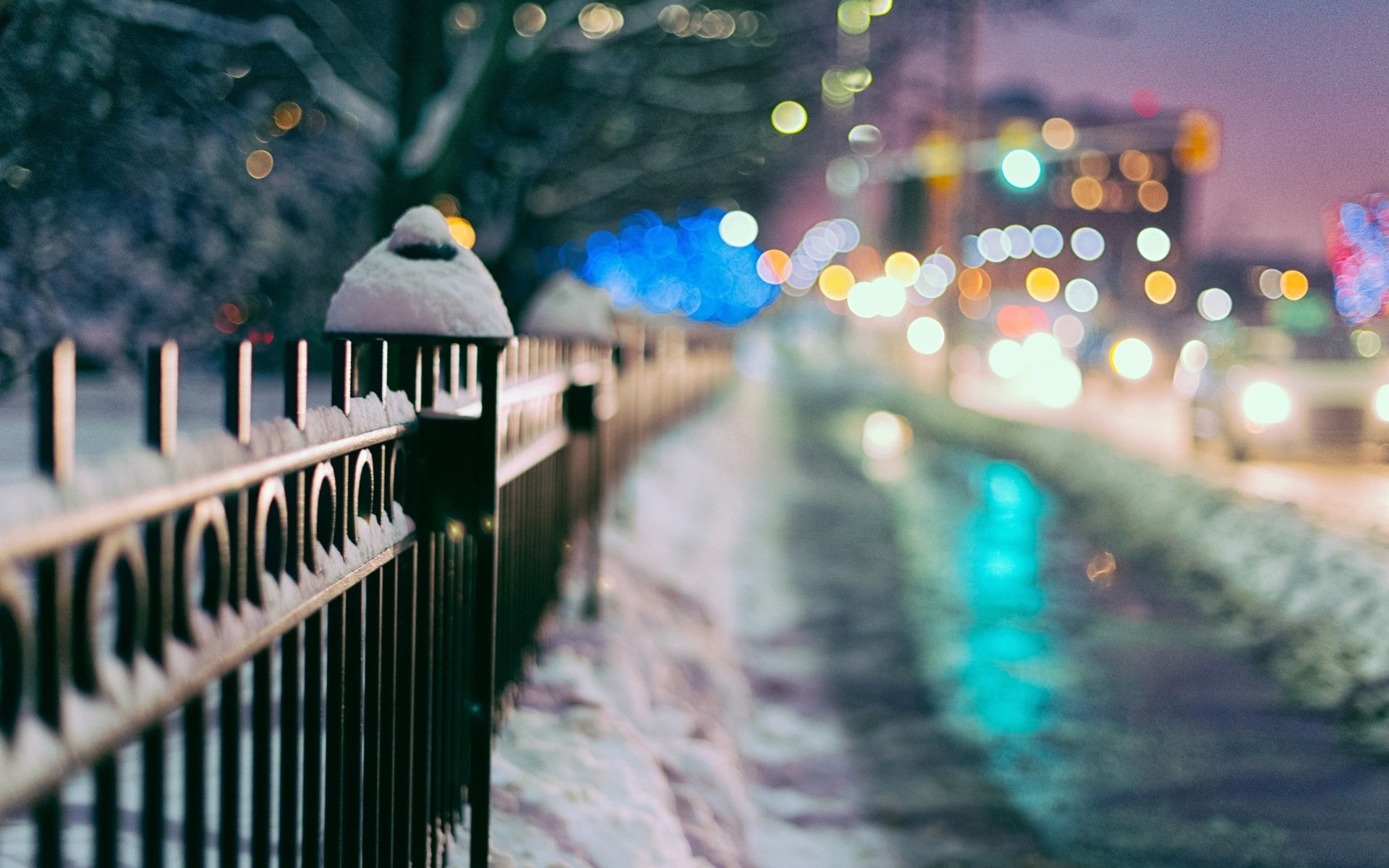Winter fence with city lights at night HD Wallpaper