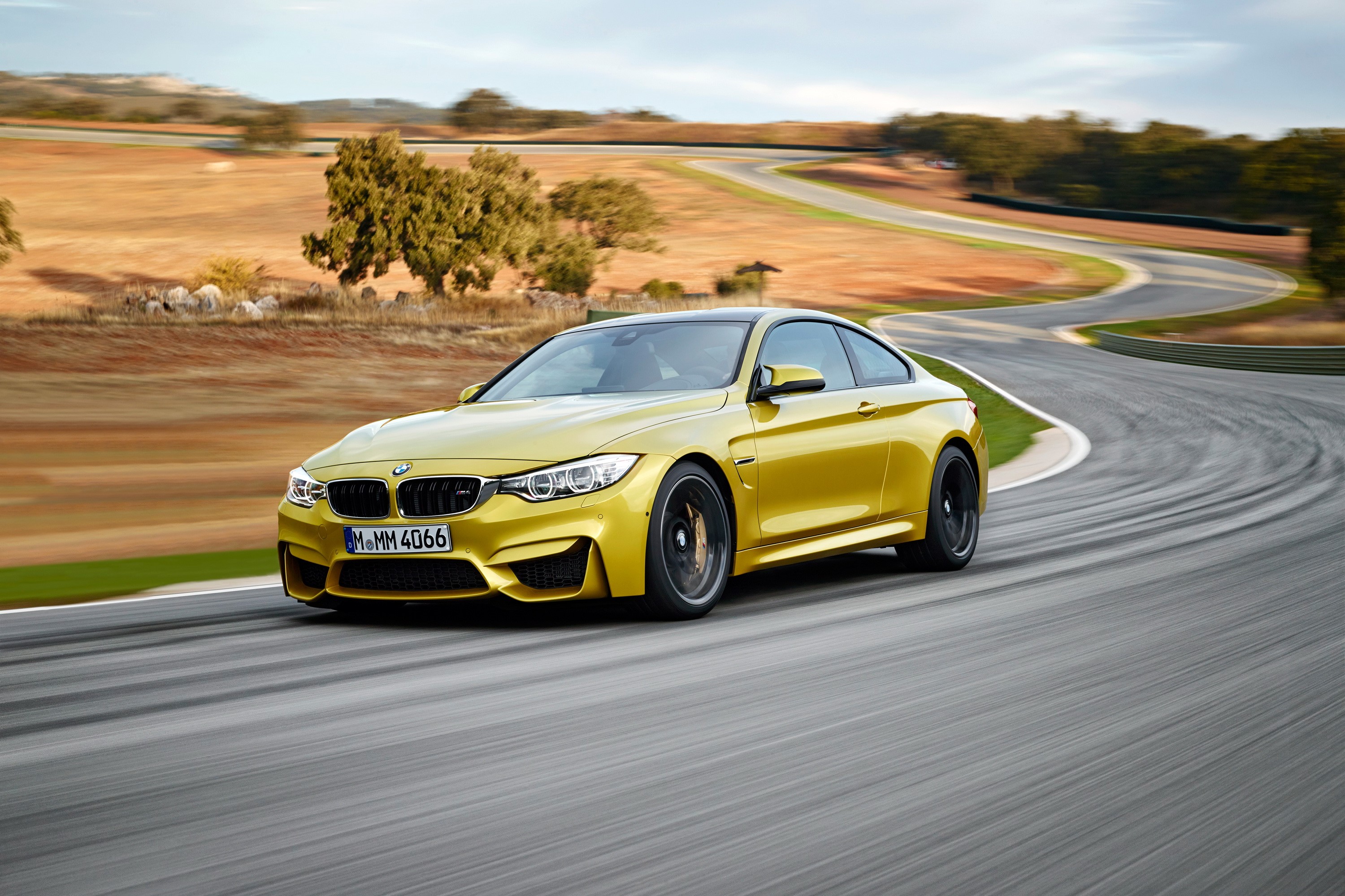 Yellow BMW M4 Coupe on a Racetrack HD Wallpaper