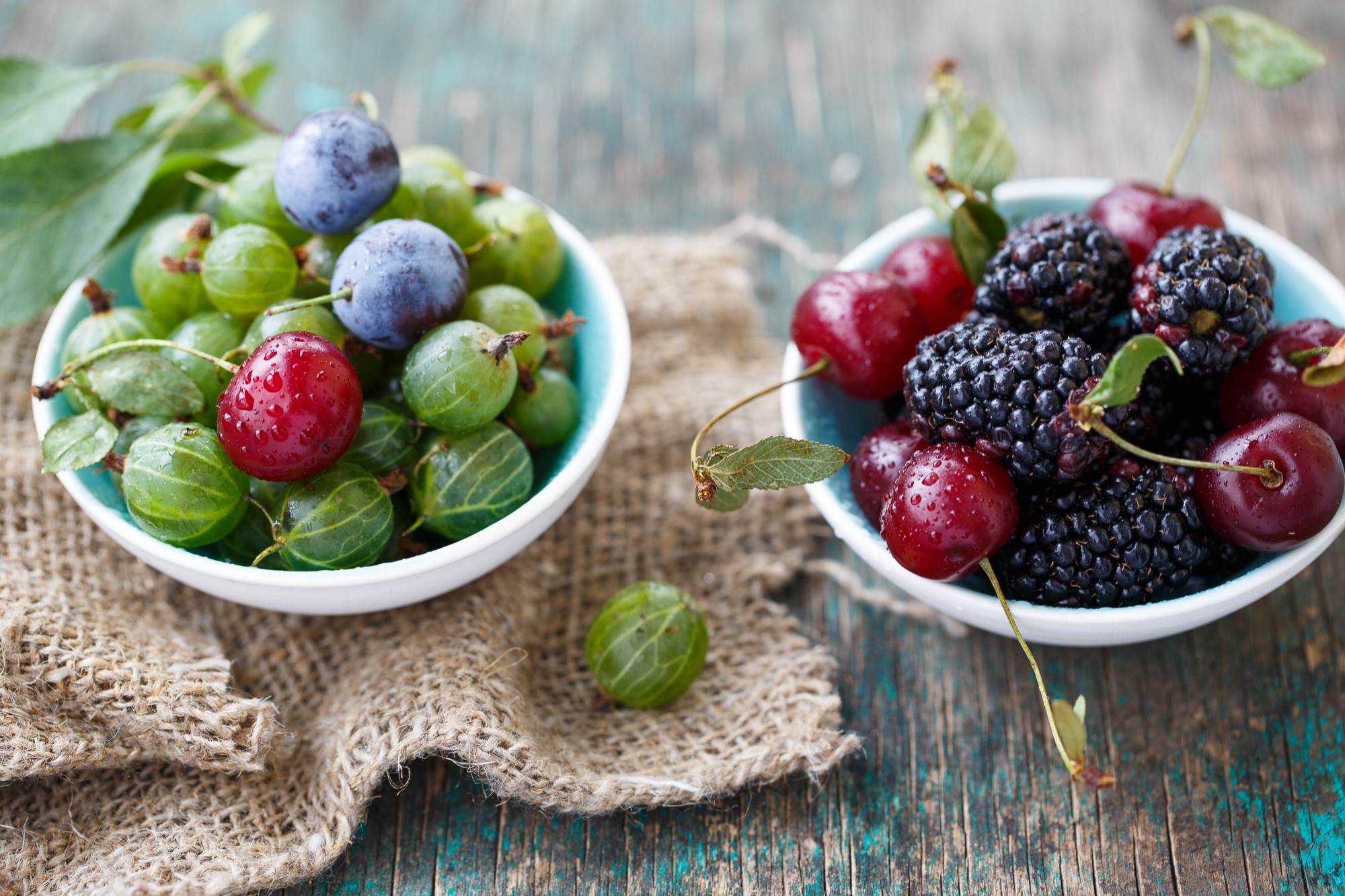 Bowls of fresh gooseberries, plums, cherries, and blackberries HD Wallpaper