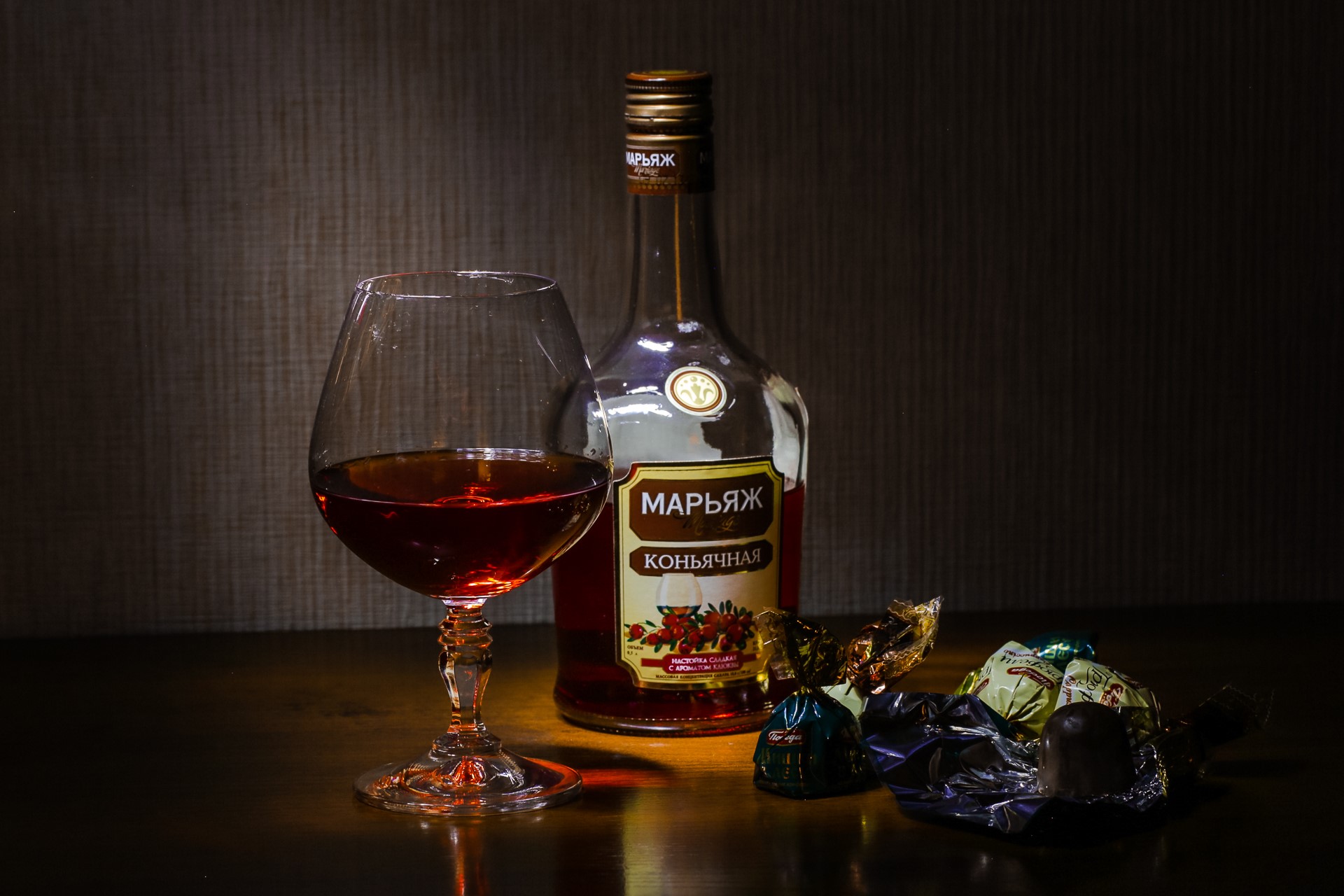 Brandy bottle and glass with chocolates HD Wallpaper