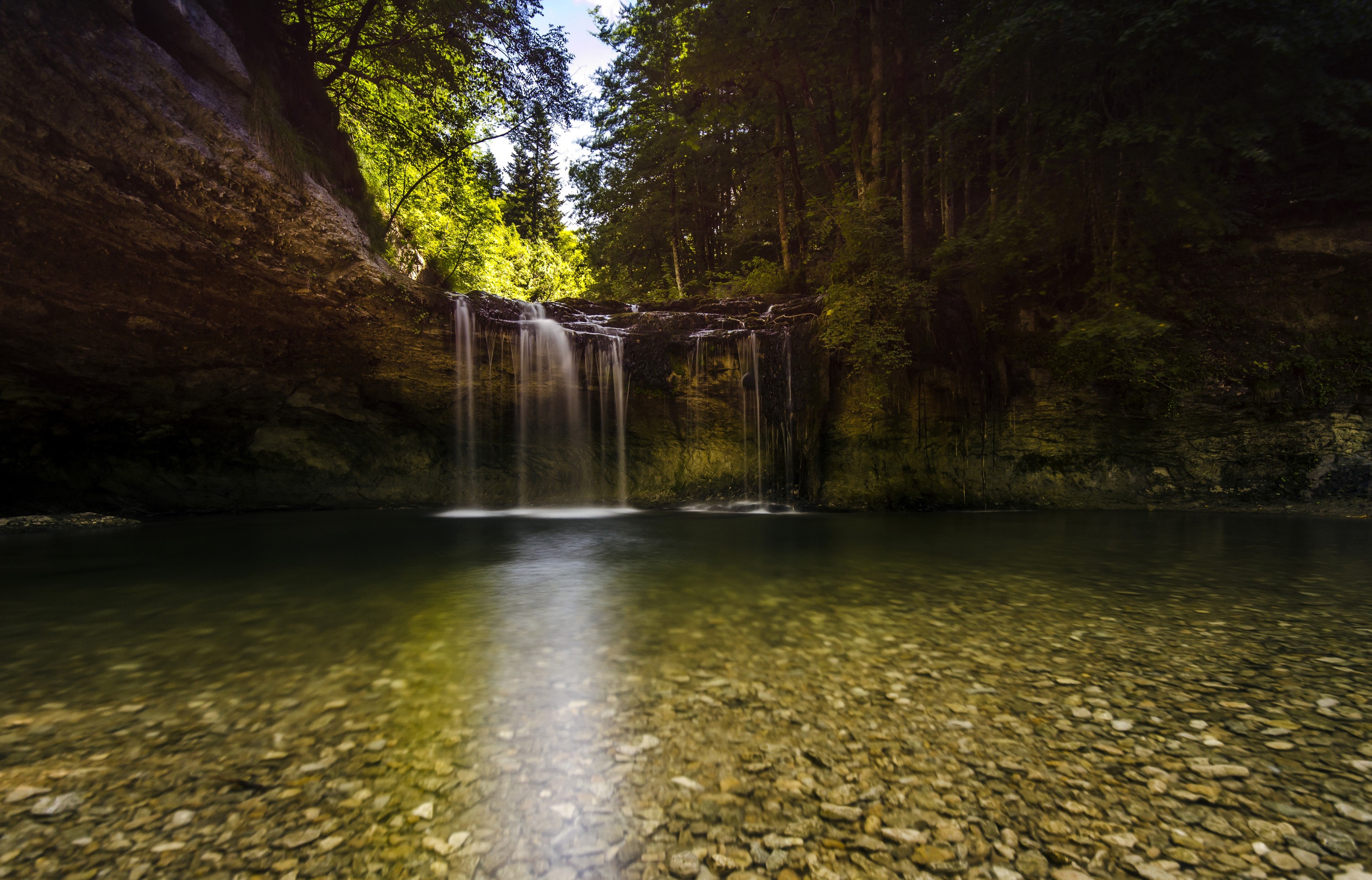 Waterfall in a forest with a rocky riverbed HD Wallpaper