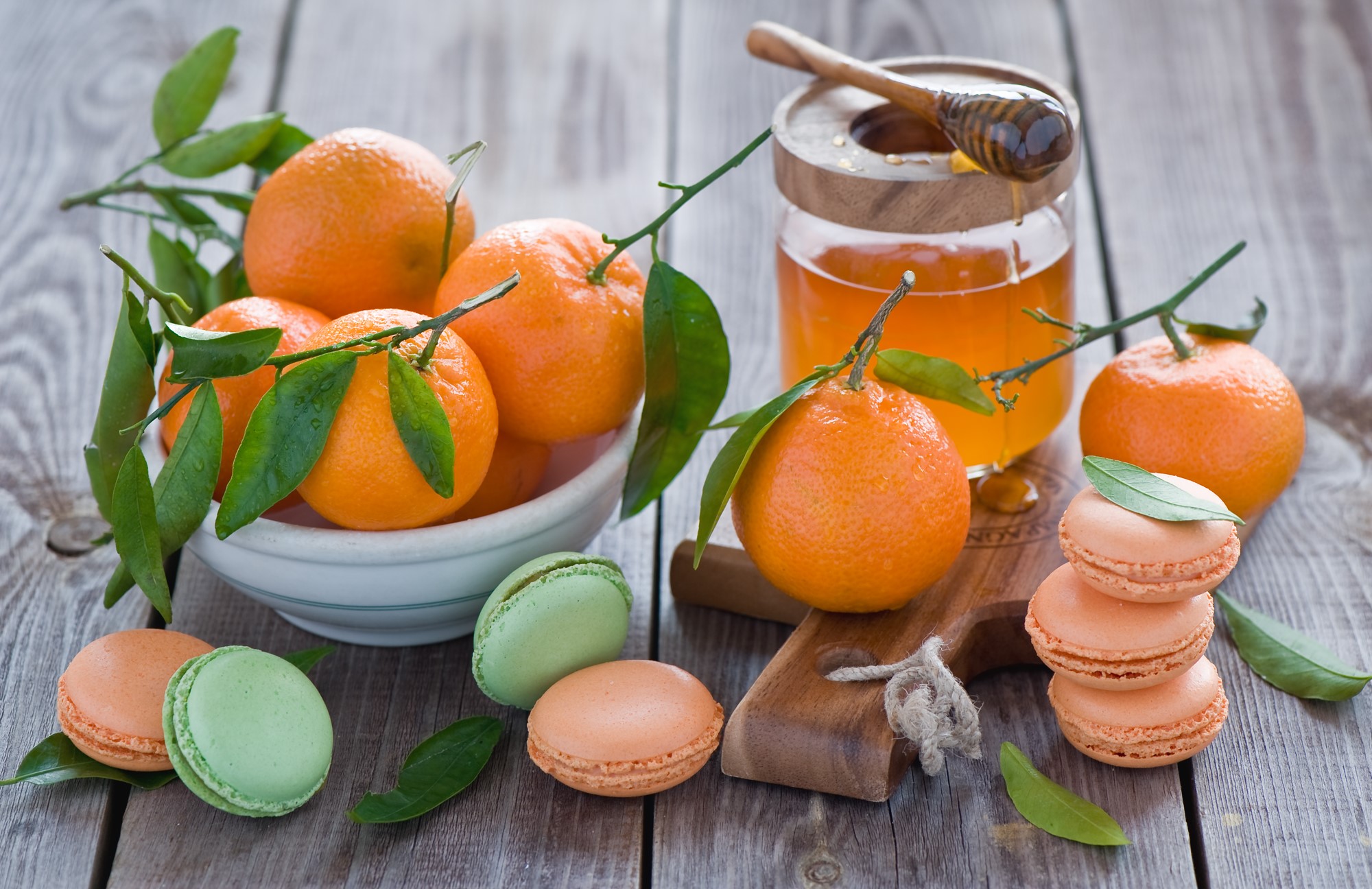 Tangerines with honey and macarons on a wooden table HD Wallpaper