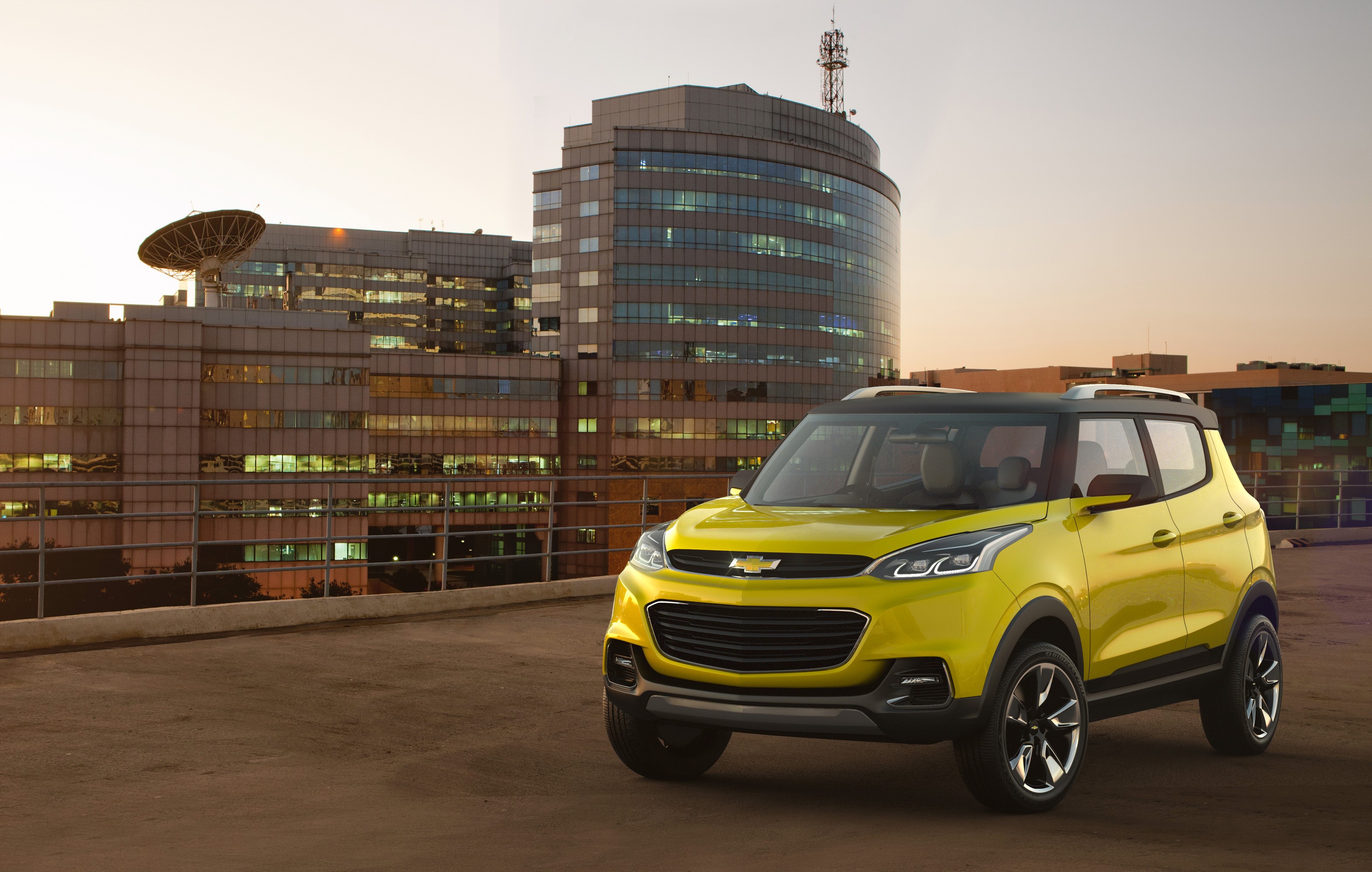 Yellow Chevrolet Adra Concept Car in front of Modern Buildings HD Wallpaper