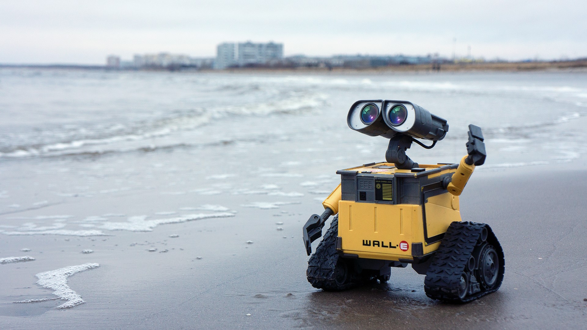 WALL·E toy on a beach with ocean waves HD Wallpaper